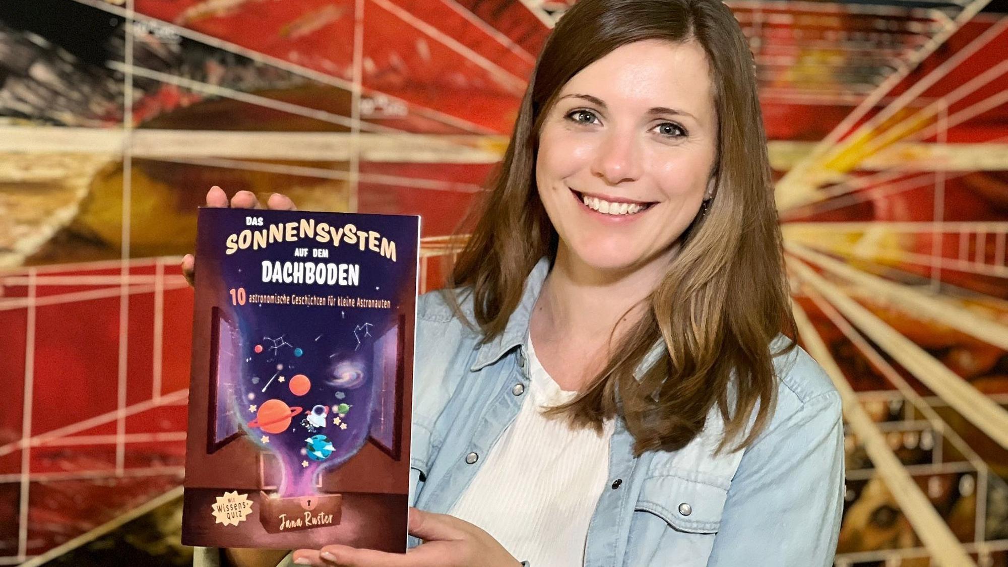 Die Autorin hält ihr neues Buch in der Hand.