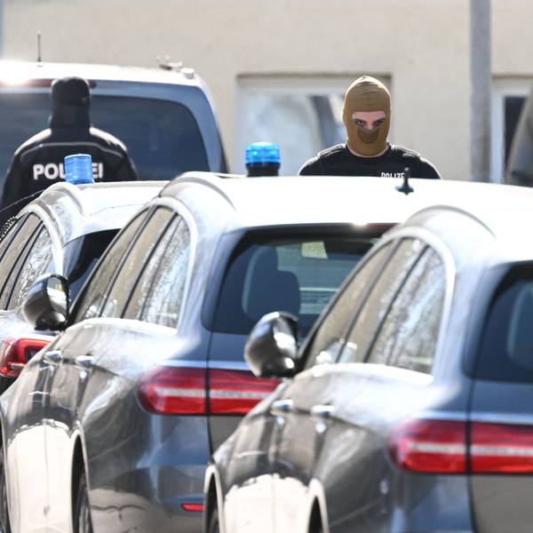 Vermummte Polizisten stehen während der Razzia im „Reichsbürger“-Milieu in Reutlingen an Fahrzeugen.