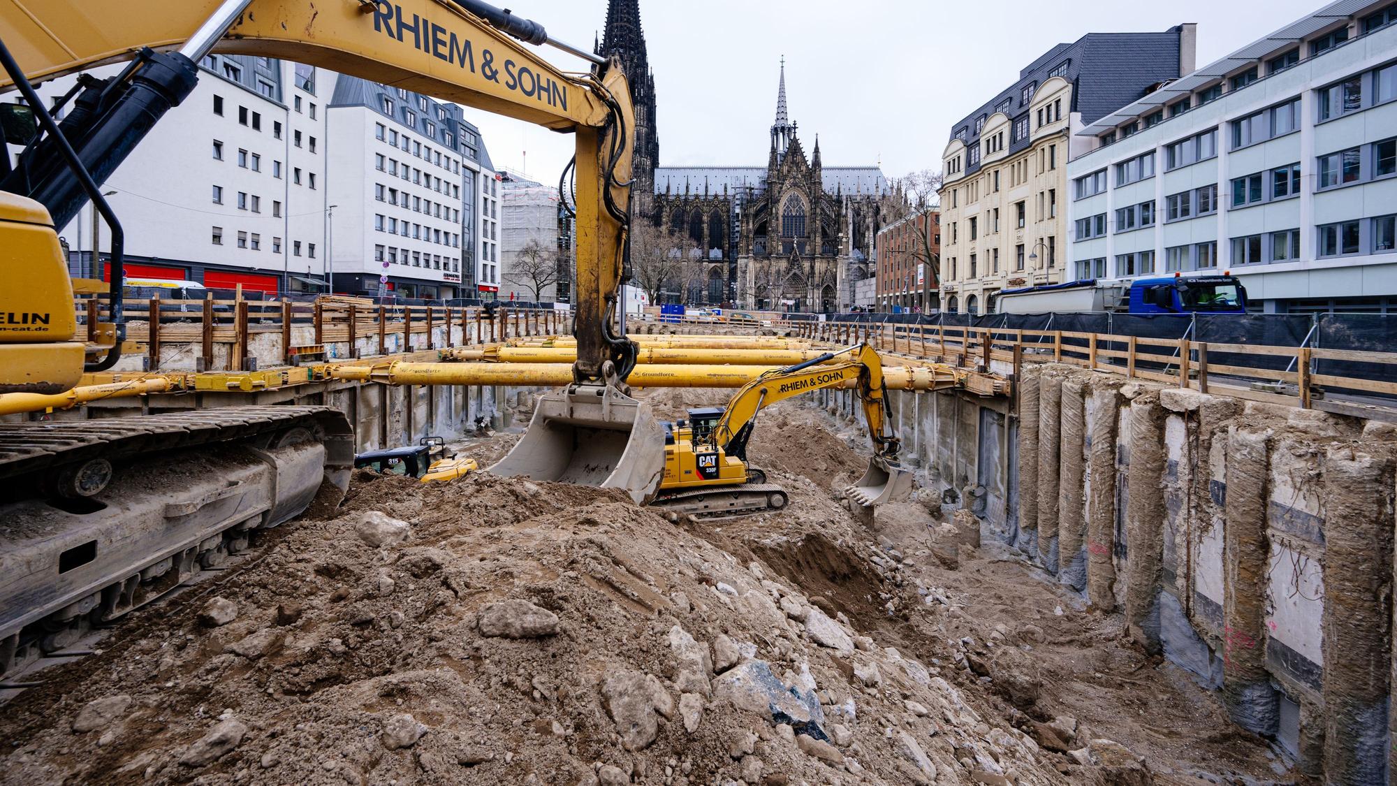 Bagger leeren die große Baugrube. Im Hintergrund ist der Dom zu sehen.