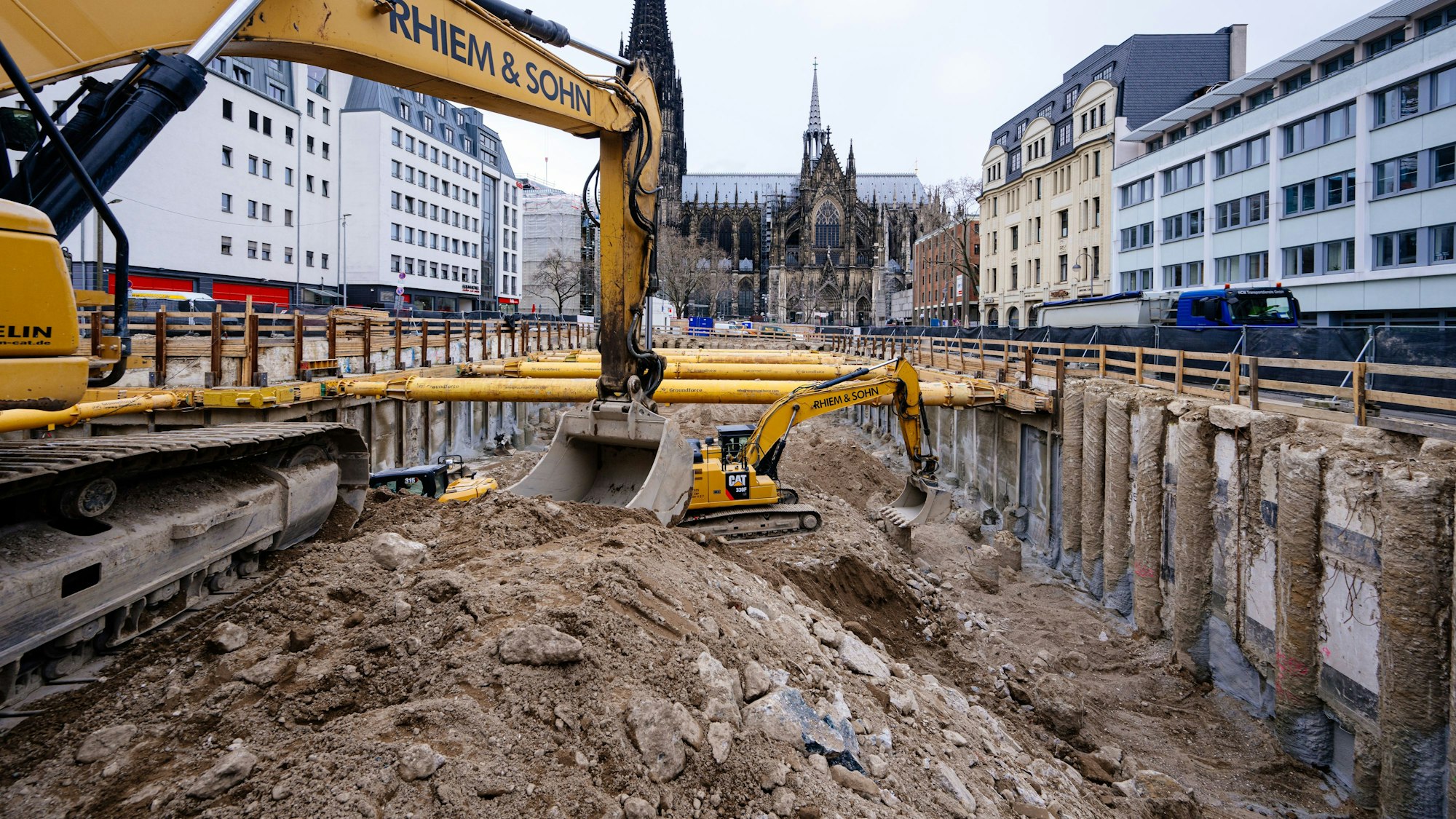 Bagger leeren die große Baugrube. Im Hintergrund ist der Dom zu sehen.