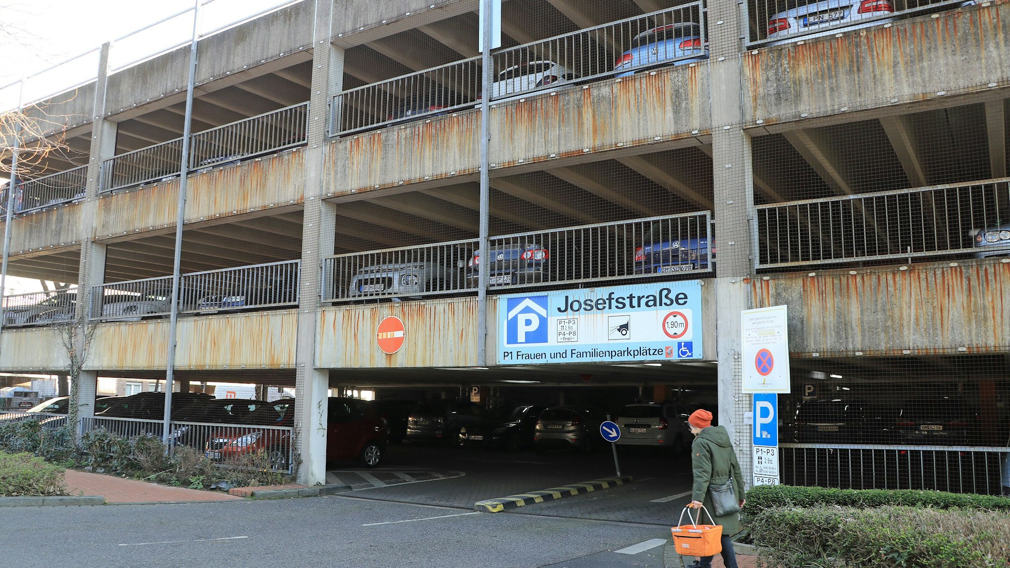 Das Bild zeigt das marode Parkhaus an der Josefstraße mit vielen parkenden Autos. Die Betonfassade ist an vielen Stellen von der Witterung braun gefärbt worden.