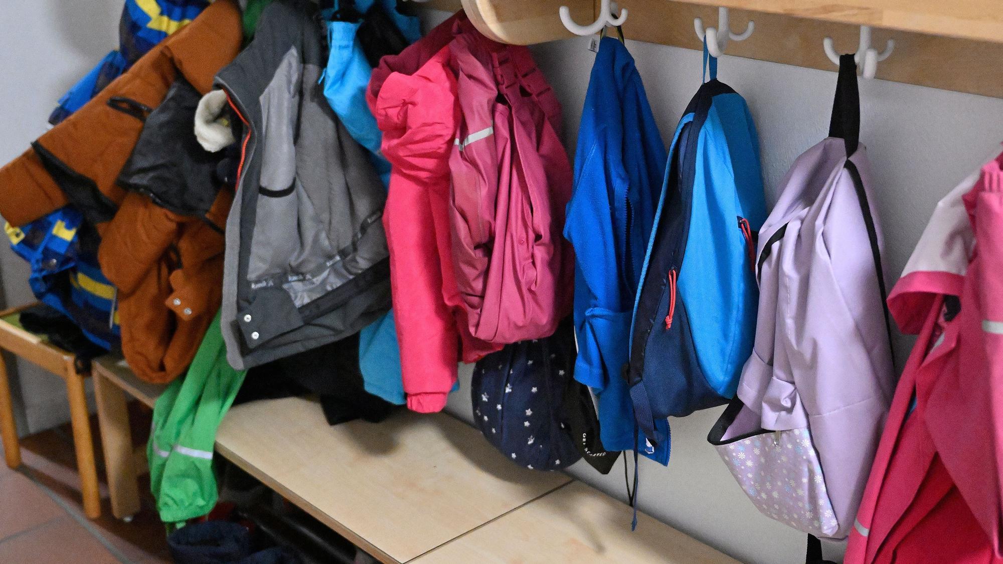 Jacken und Mäntel hängen an einer Garderobe.