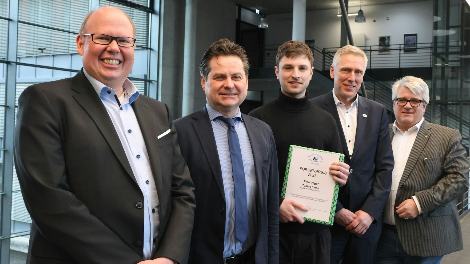 Zu sehen ist eine Preisverleihung an einen jungen Mann.