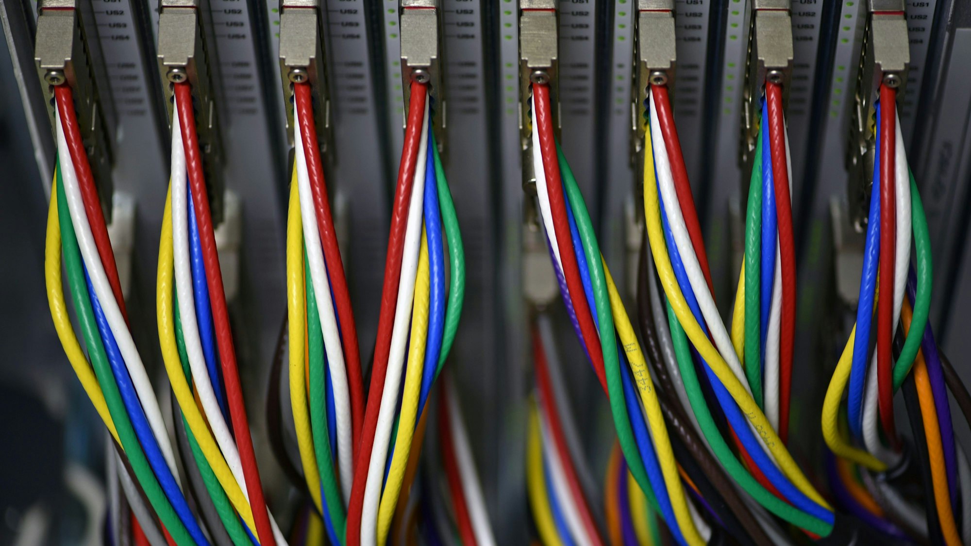 Man sieht bunte Kabel, die aus einer Station kommen.