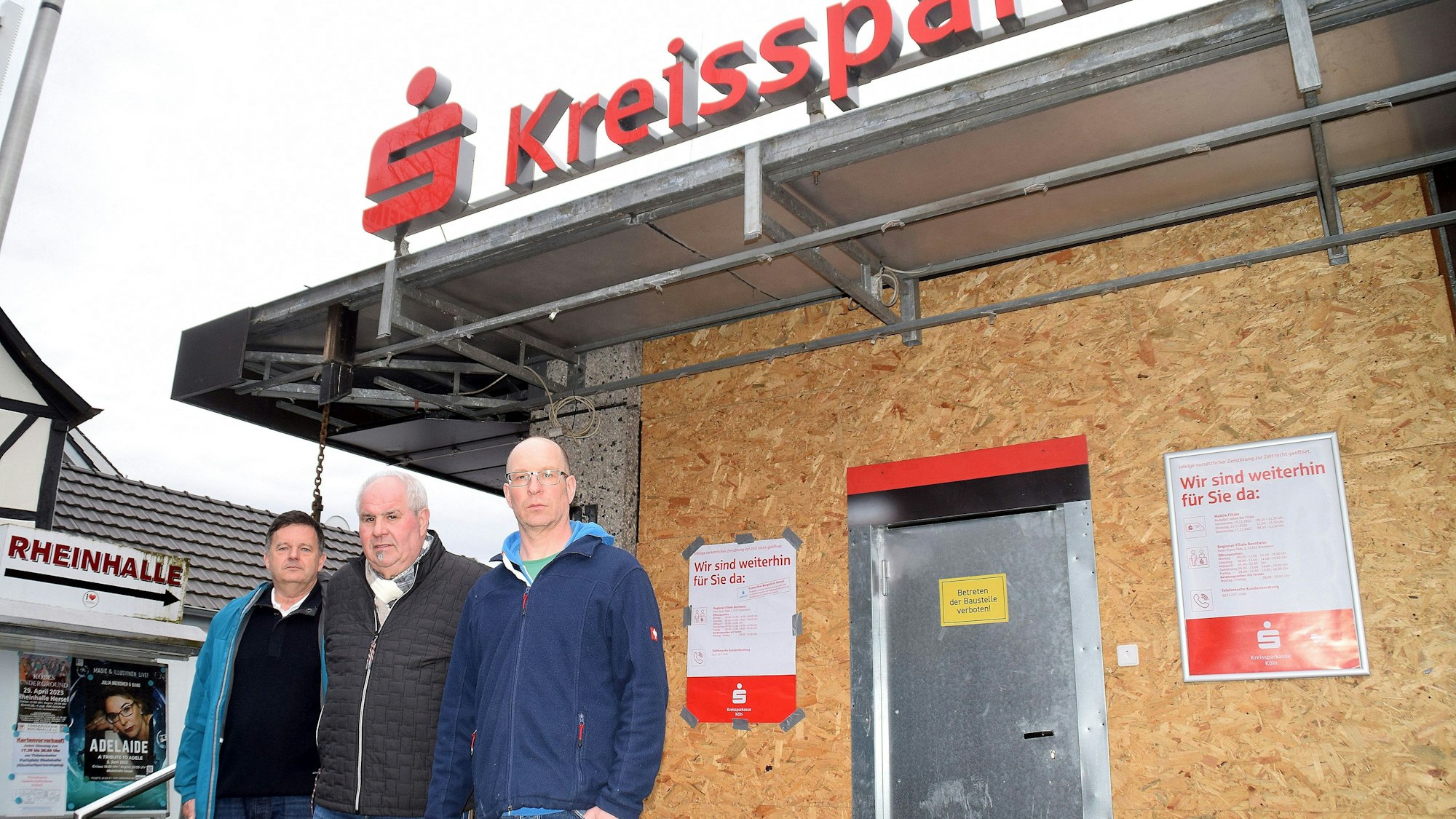 Die drei Ortsvorsteher der Bornheimer Rheinorte Bernd Marx (Uedorf), Toni Breuer (Hersel) und Christoph Kany (Widdig) (von links) kritisieren, dass sich seit der Geldautomatensprengung im November 2022 in der Filiale der Kreissparkasse Hersel nichts mehr getan hat. Sie starteten jetzt eine Unterschriftenaktion zum Erhalt der Filiale.