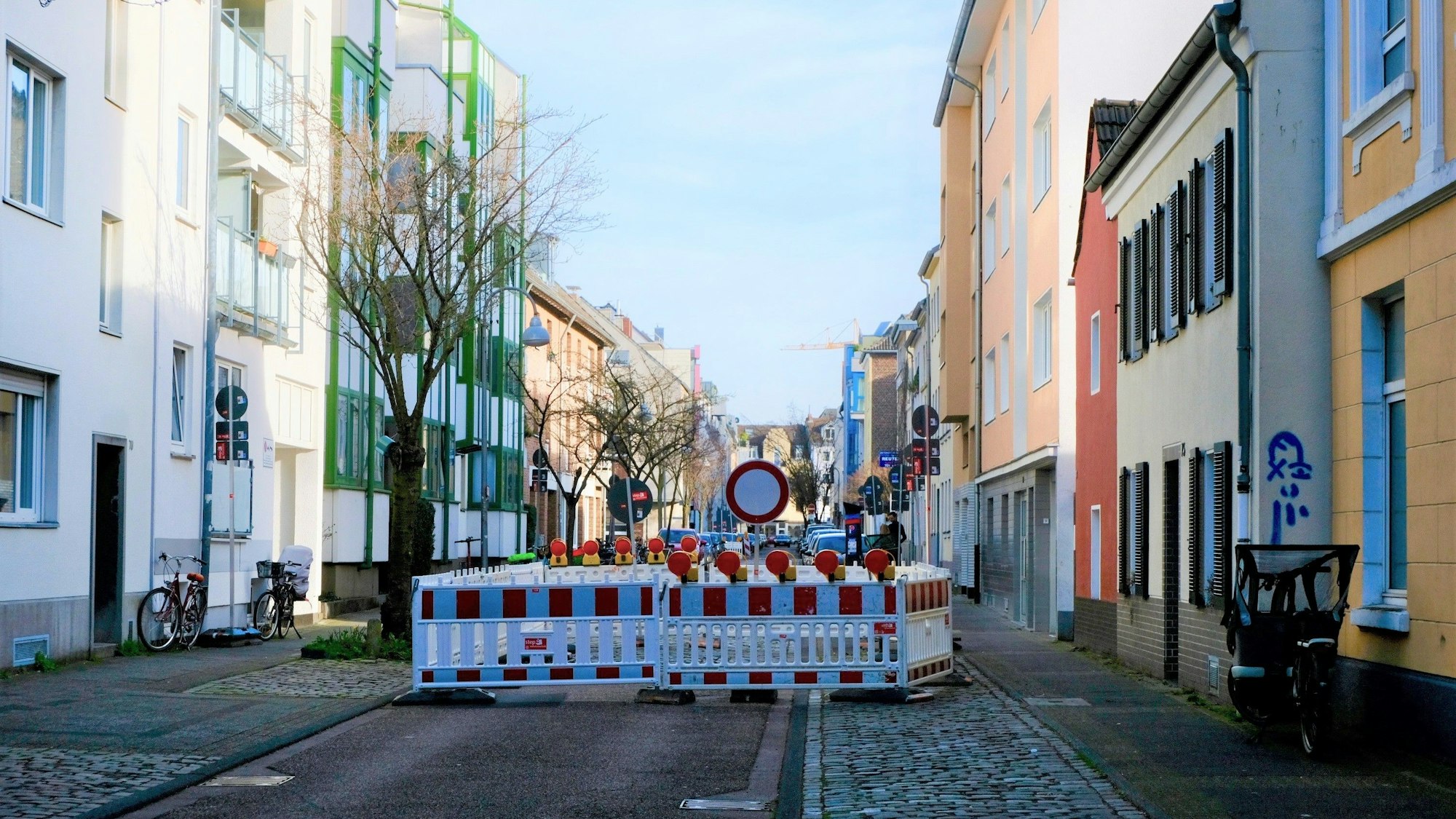 Schilder und Baustellenabsperrungen weisen an der Straße auf eine Sperrung hin.