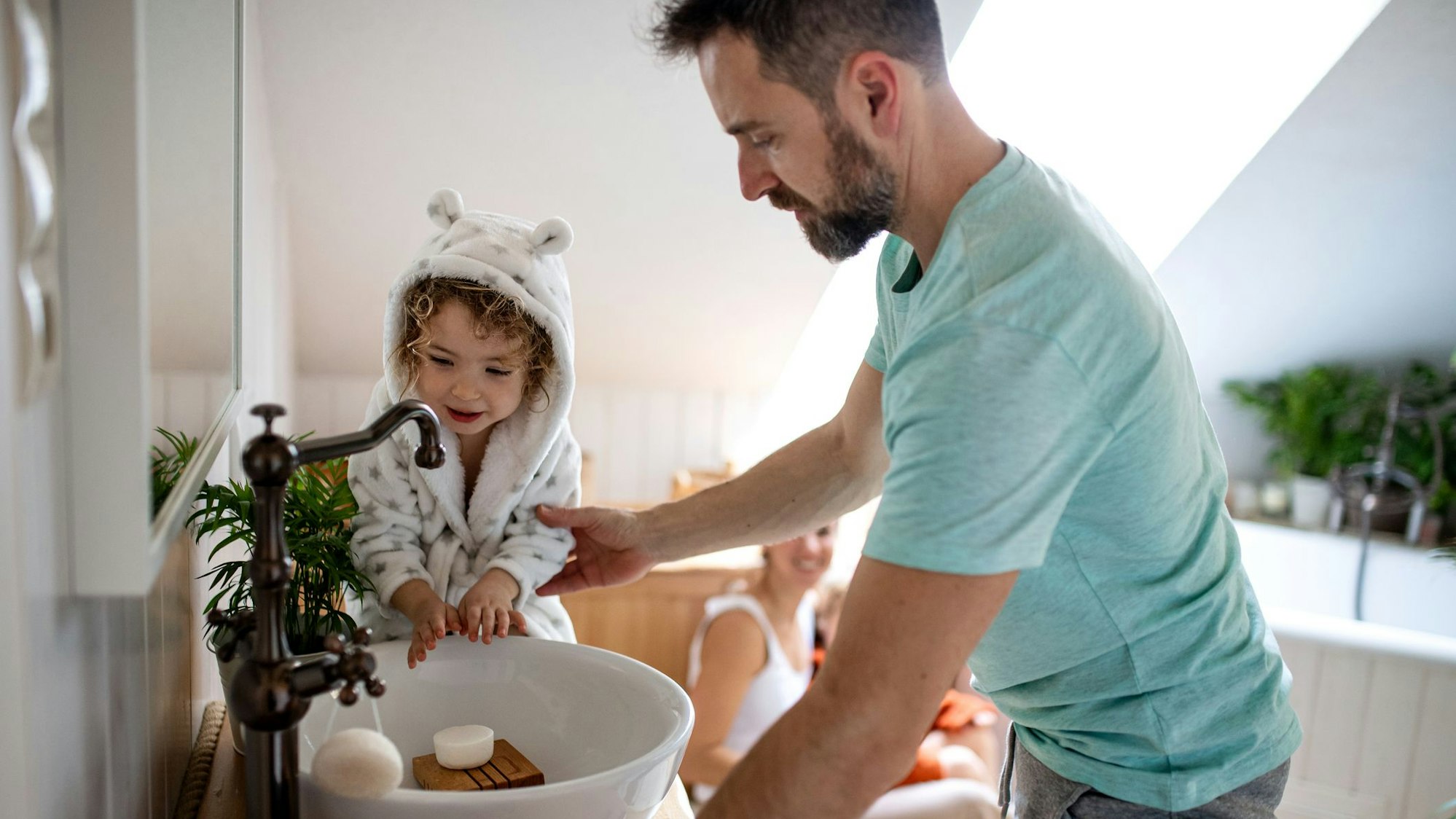 Vater wäscht mit seiner kleinen Tochter die Hände.