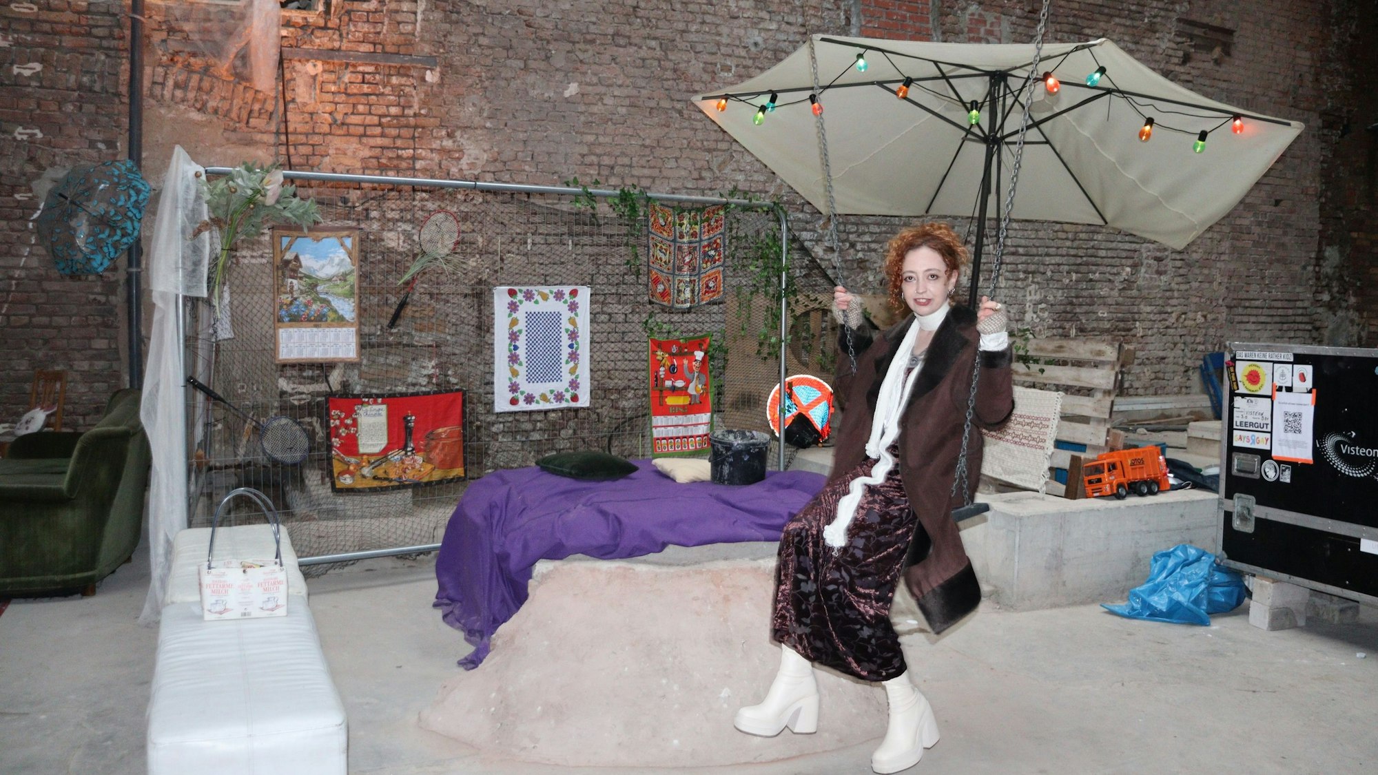 Eine Frau sitzt inmitten einer Kunst-Installation.