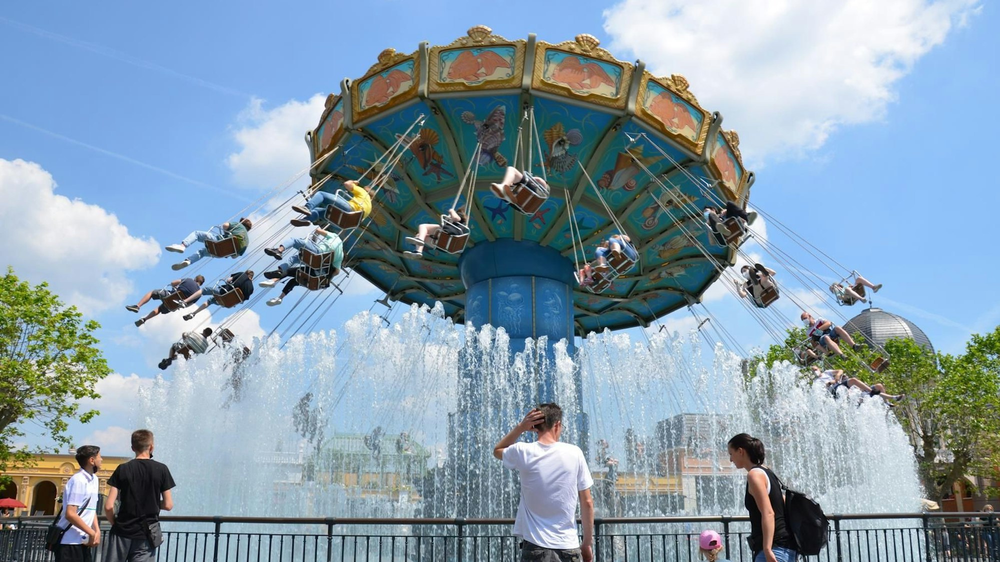 Personen stehen vor dem Kettenkarusell