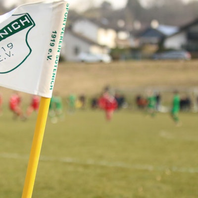 Die Fahne des SV Sötenich weht am Rande des Fußballplatzes.