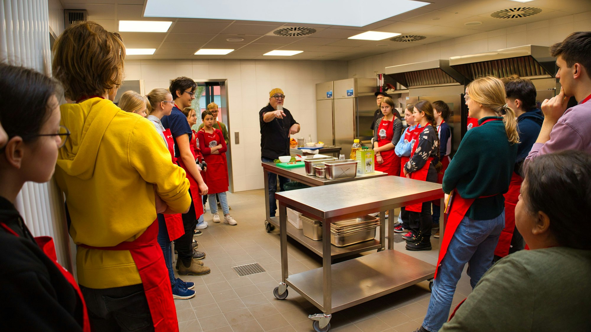 Sfefan Marquard erklärt den Schülern in der Küche etwas.
