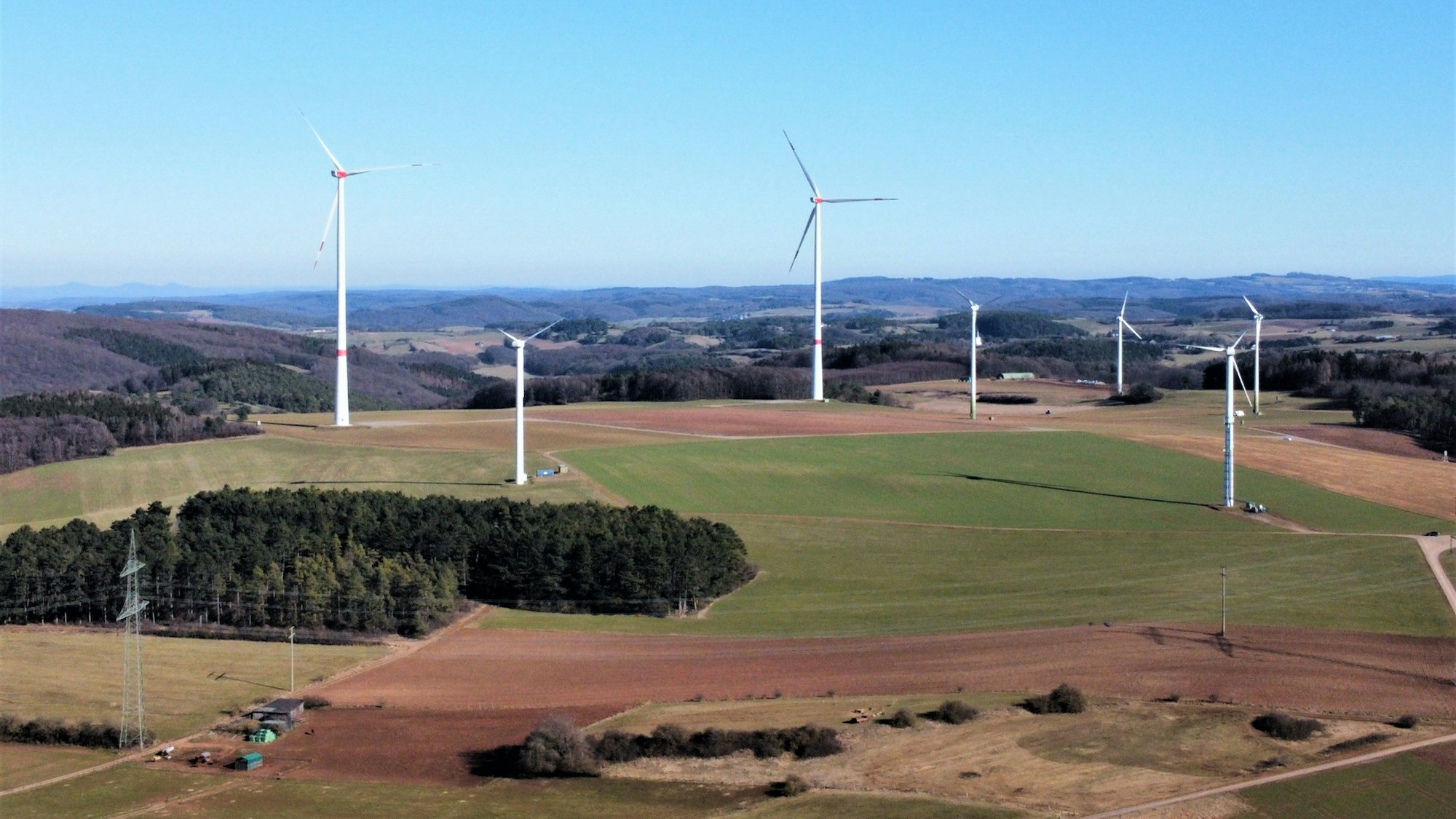 Das Drohnenfoto zeigt sieben Windkraftanlagen in der Landschaft bei Kall.
