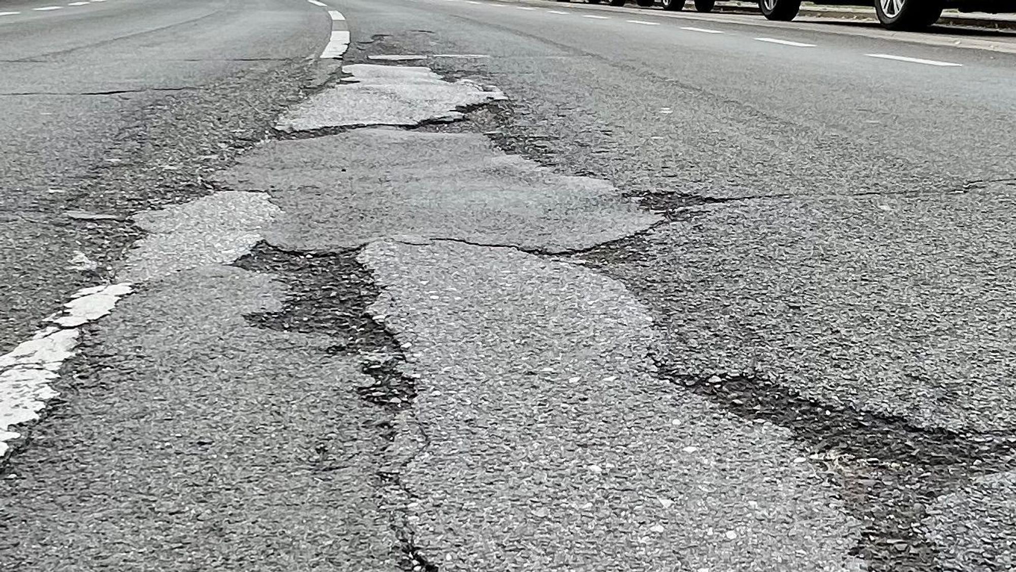 Tiefe Schlaglöcher auf einer Straße.