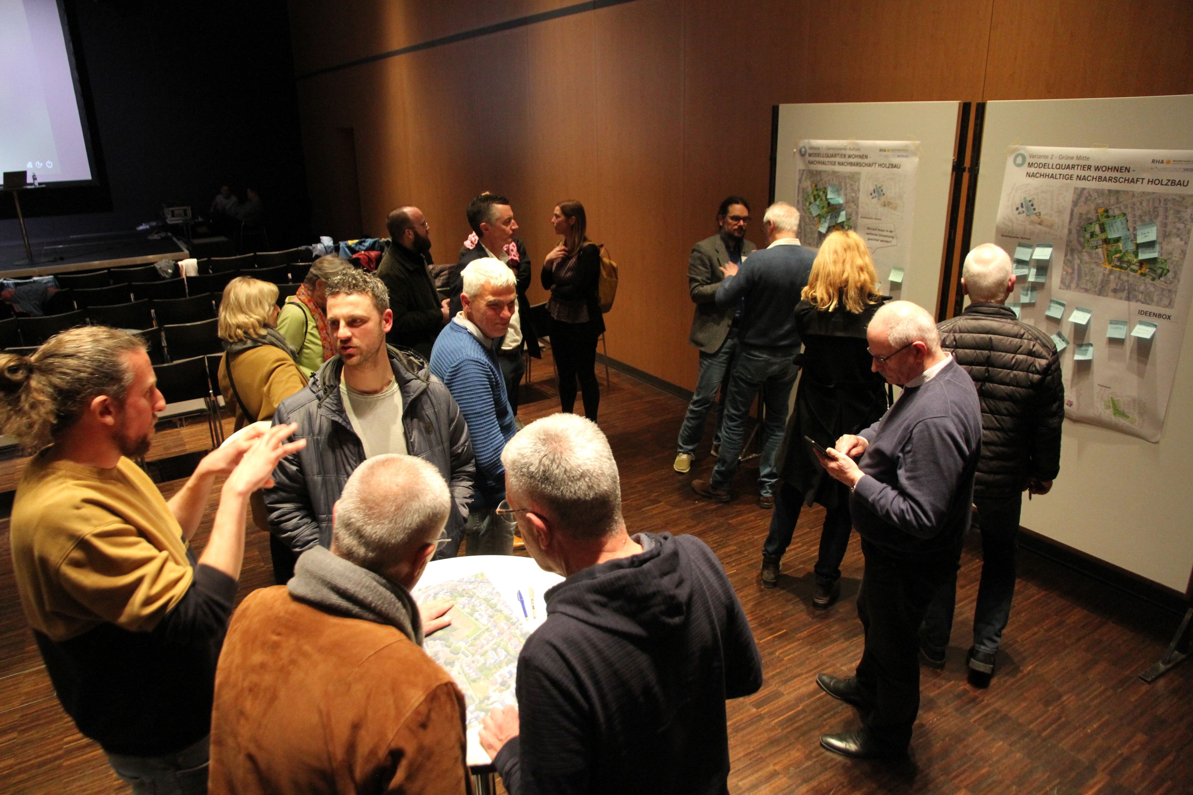 Mehrere Menschen stehen vor Pinnwänden im Rhein-Sieg-Forum und diskutieren.