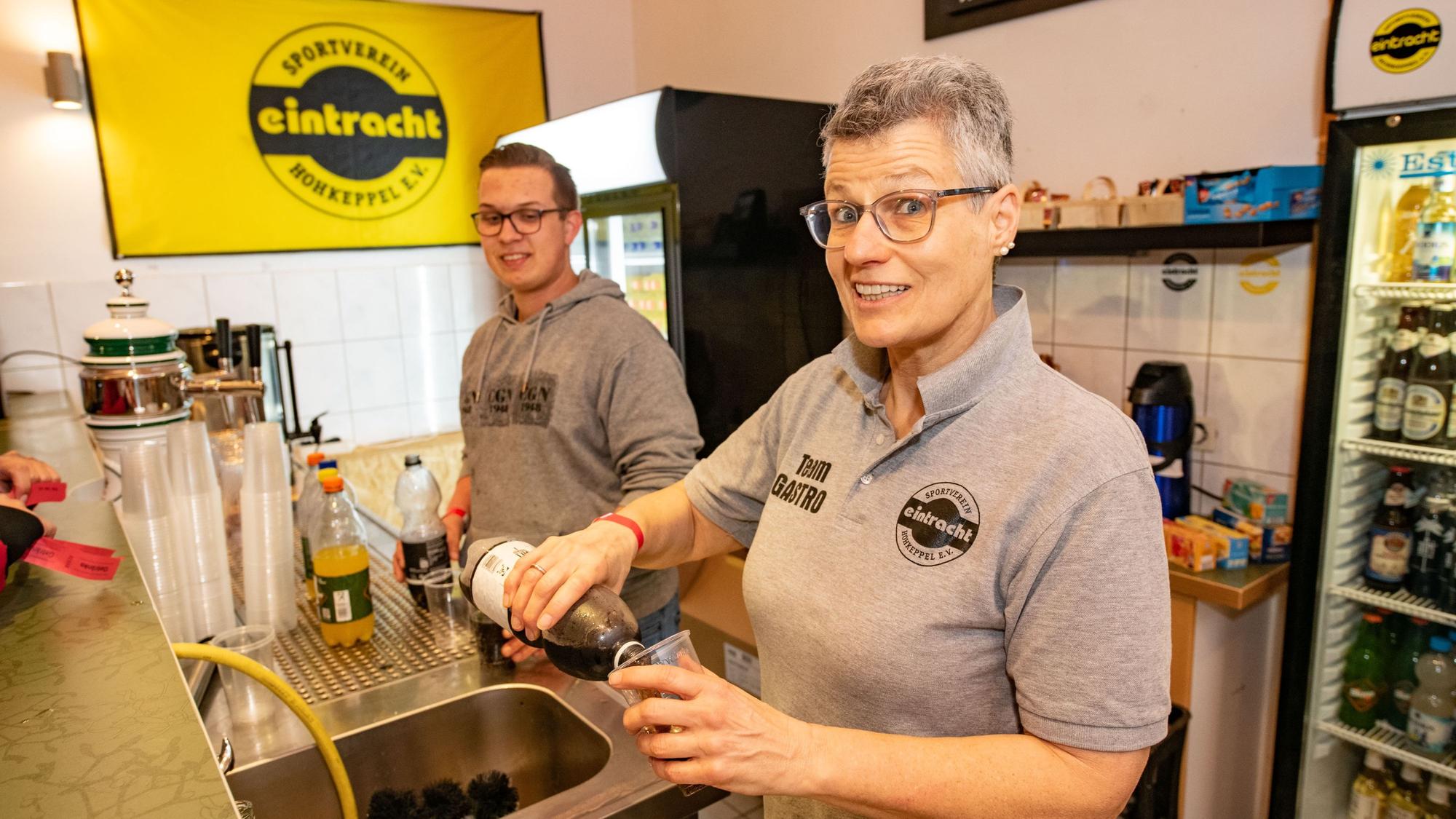 Eine Frau und ein Mann am Getränkestand.