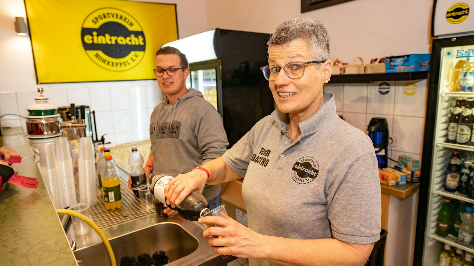 Eine Frau und ein Mann am Getränkestand.