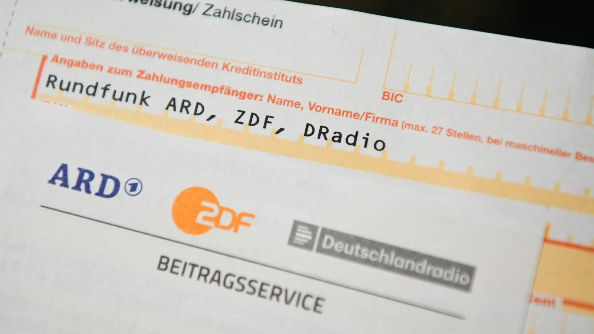 Auf einem Tisch liegt ein Anschreiben und Überweisungsträger für die Rundfunkgebühren.