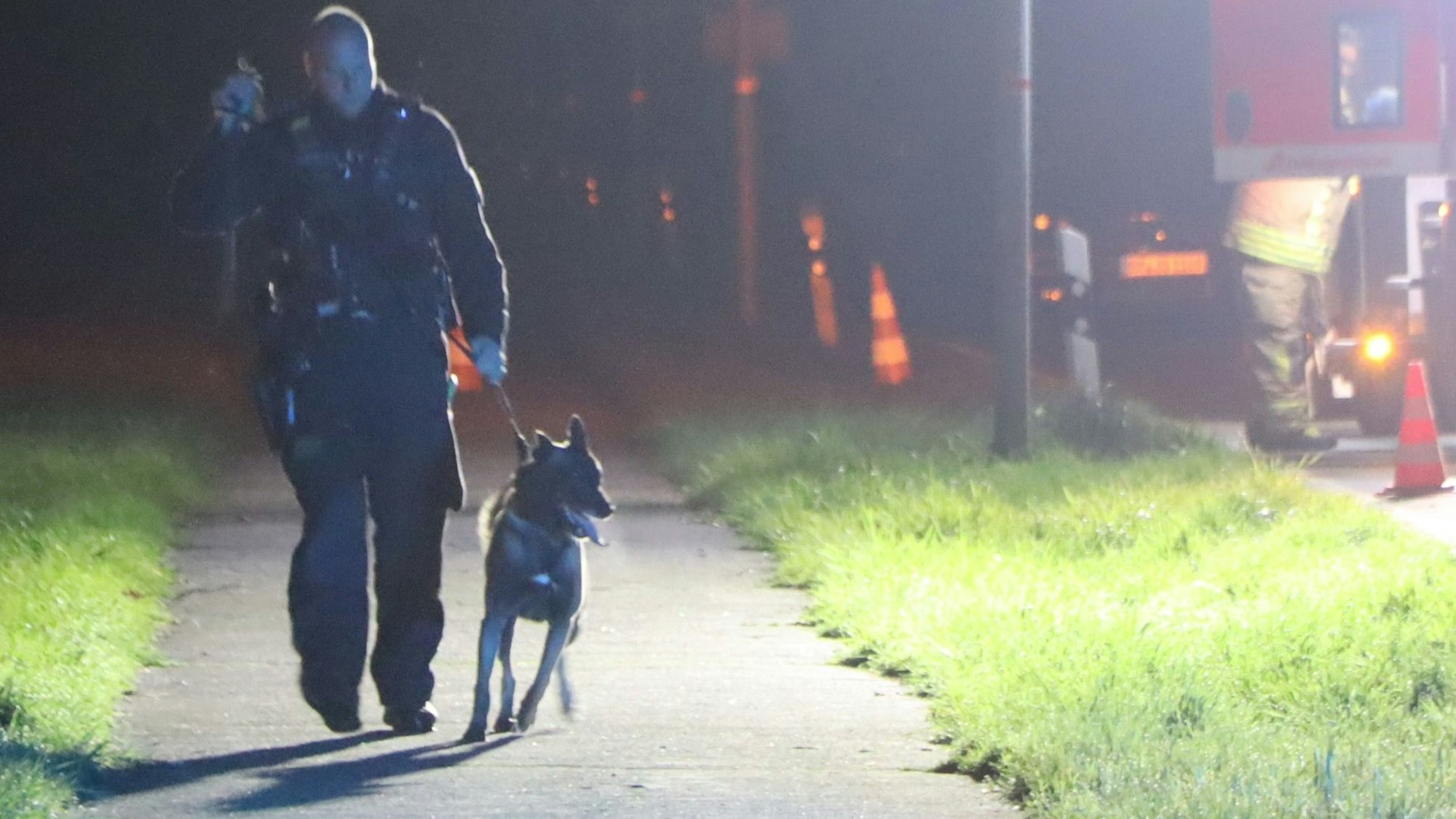 Ein Polizist geht mit einem Hund an der Leine.