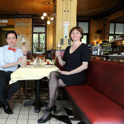Vincent und Liliane Moissonnier sitzen an einem Tisch in ihrem Restaurant.