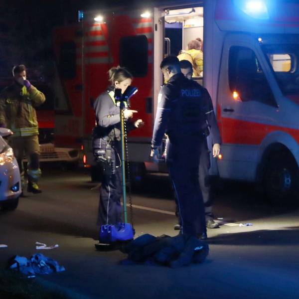 Es ist ein Rettungswagen zu sehen. Davor stehen mehrere Polizisten und Sanitäter an der Unfallstelle.