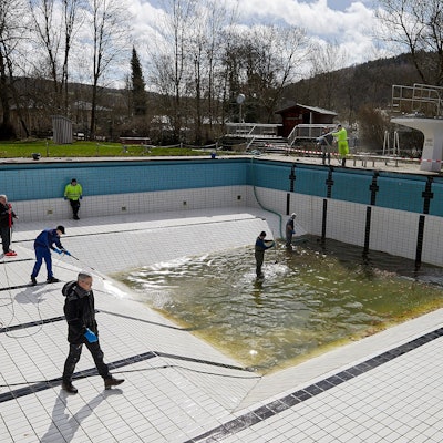 Freiwillige säubern mit Hochdruckreinigern und Schrubbern das Becken.