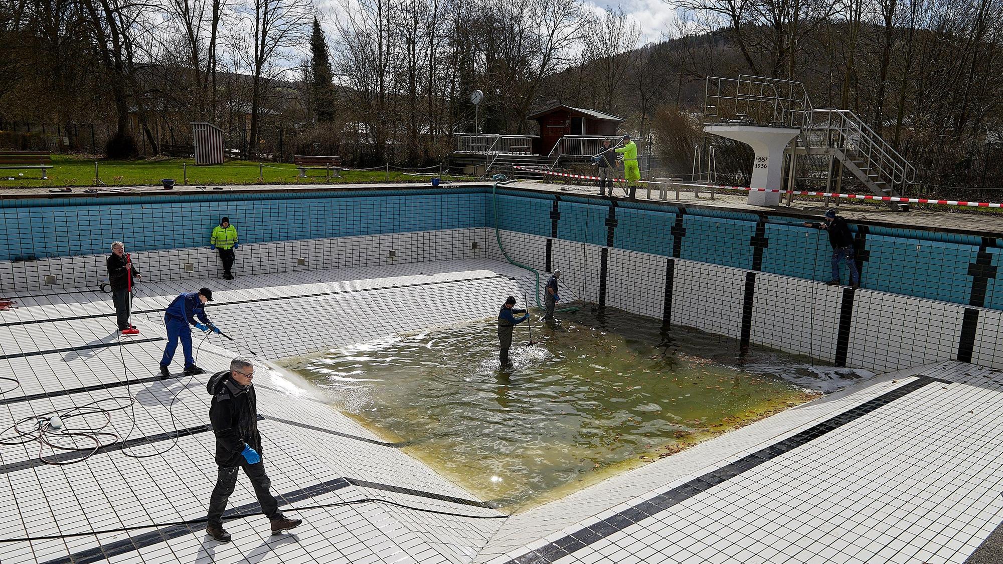 Freiwillige säubern mit Hochdruckreinigern und Schrubbern das Becken.