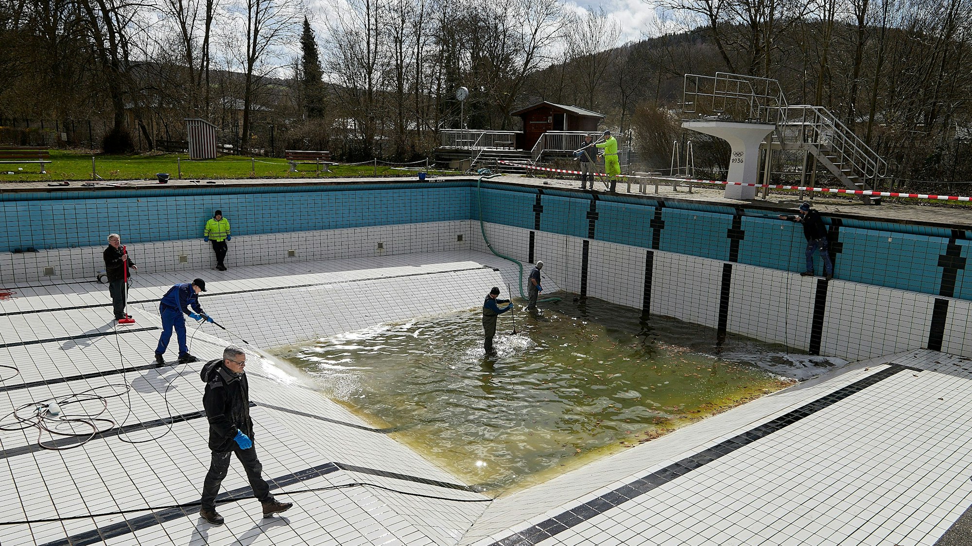 Freiwillige säubern mit Hochdruckreinigern und Schrubbern das Becken.