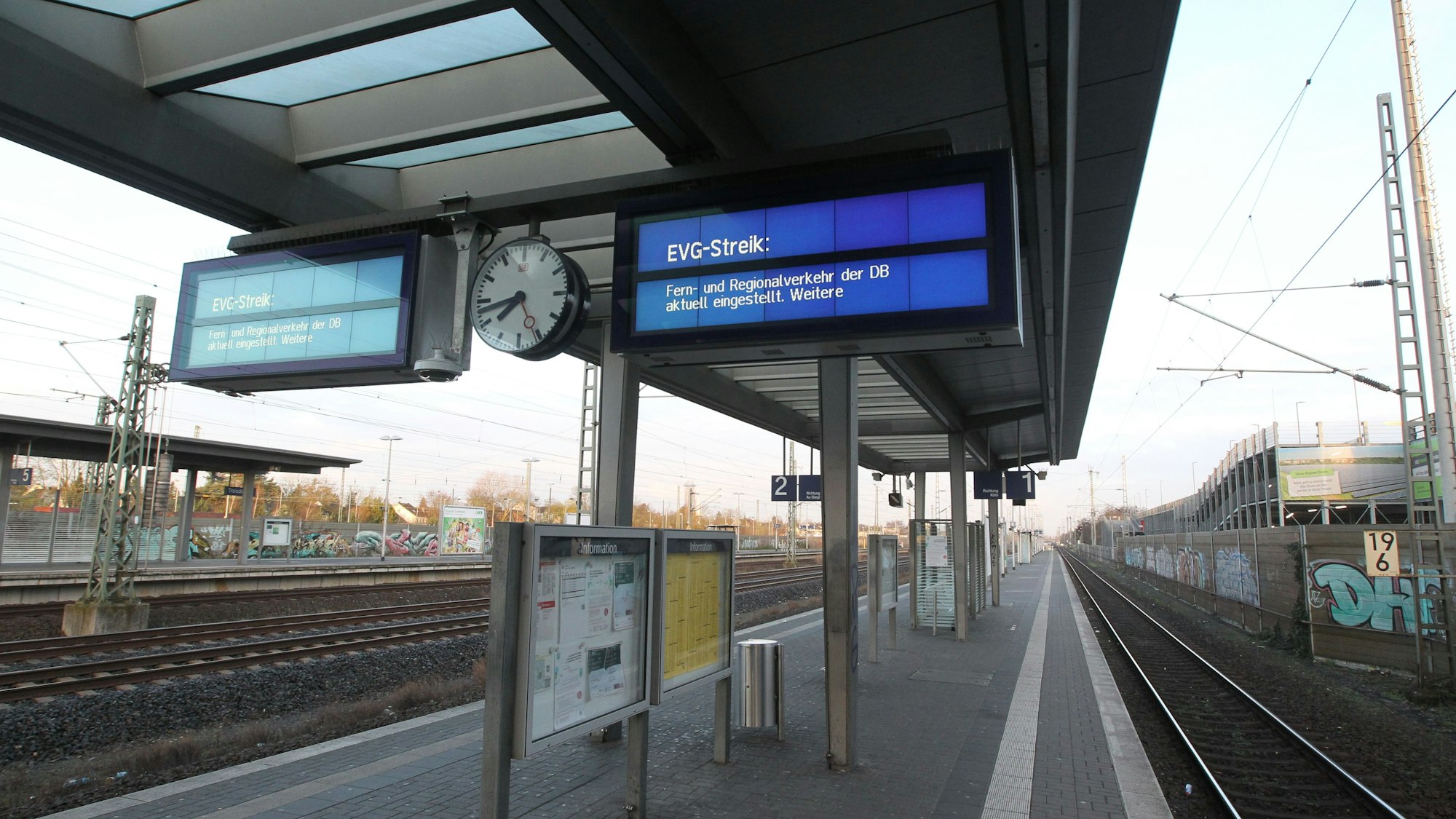 Über menschenleeren Bahnsteigen hängen zwei Anzeigetafeln, auf denen über den Streik informiert wird.
