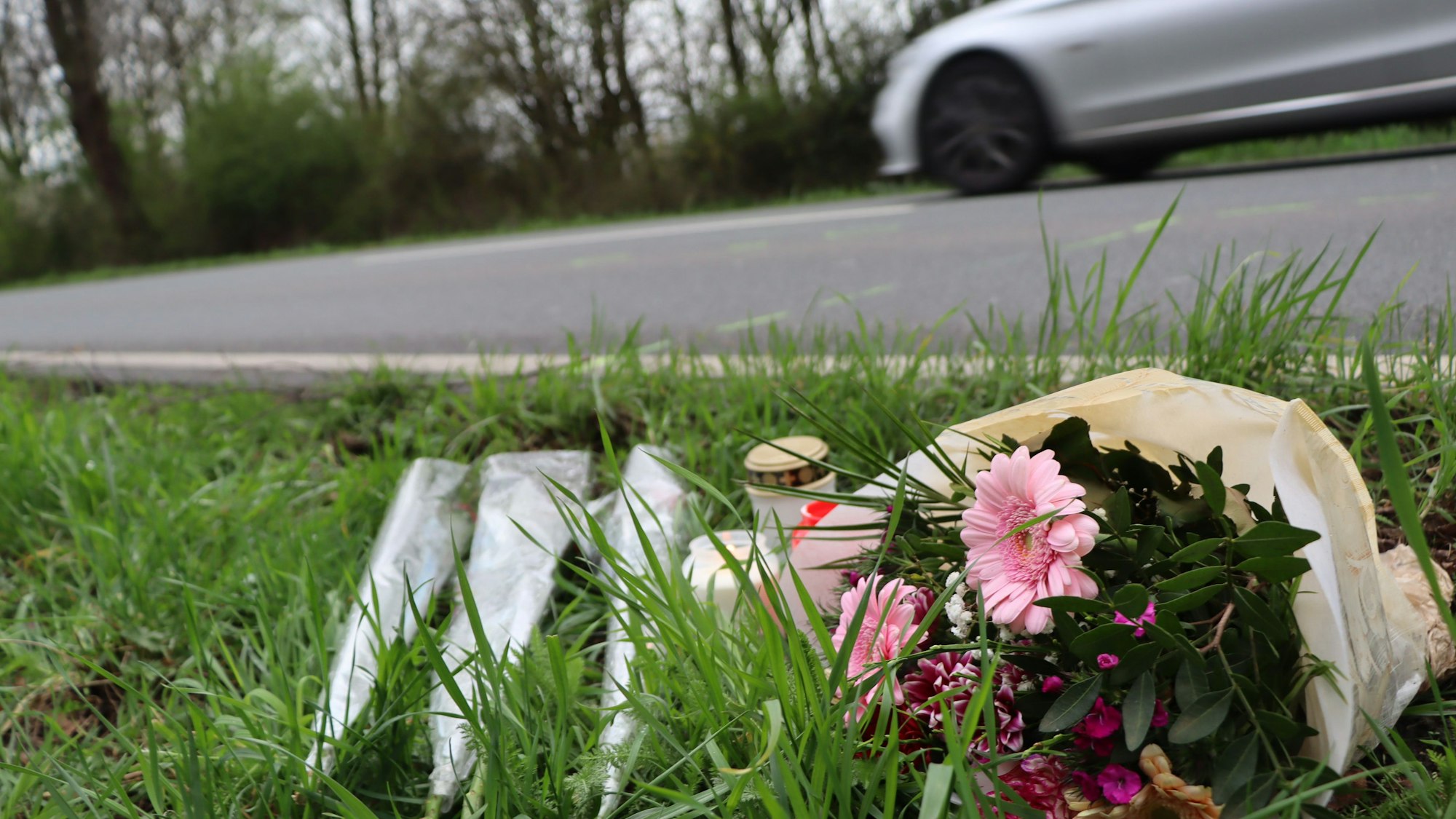 Blumen und Kerzen an der Unfallstelle an der Rodenkirchener Straße in Wesseling.