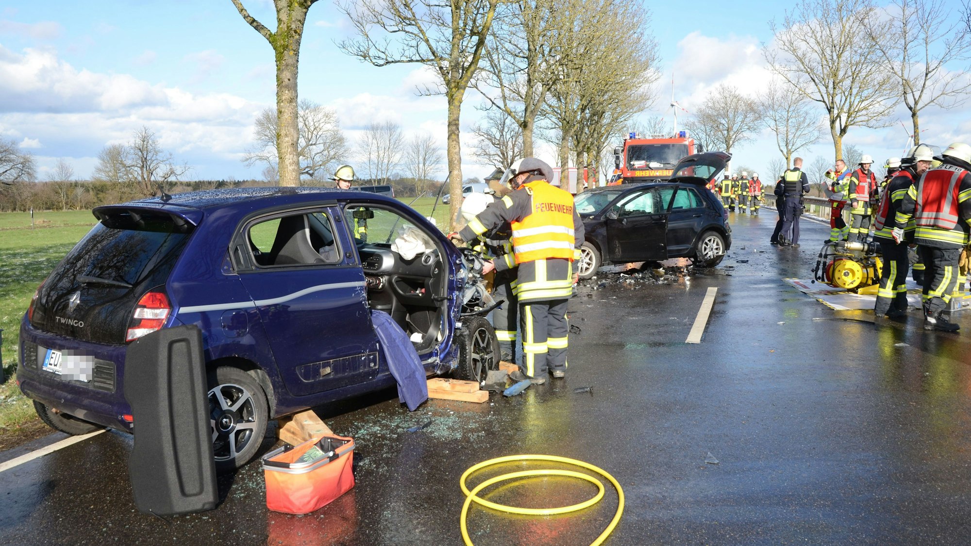 Feuerwehrleute arbeiten an den beiden stark beschädigten Autos.