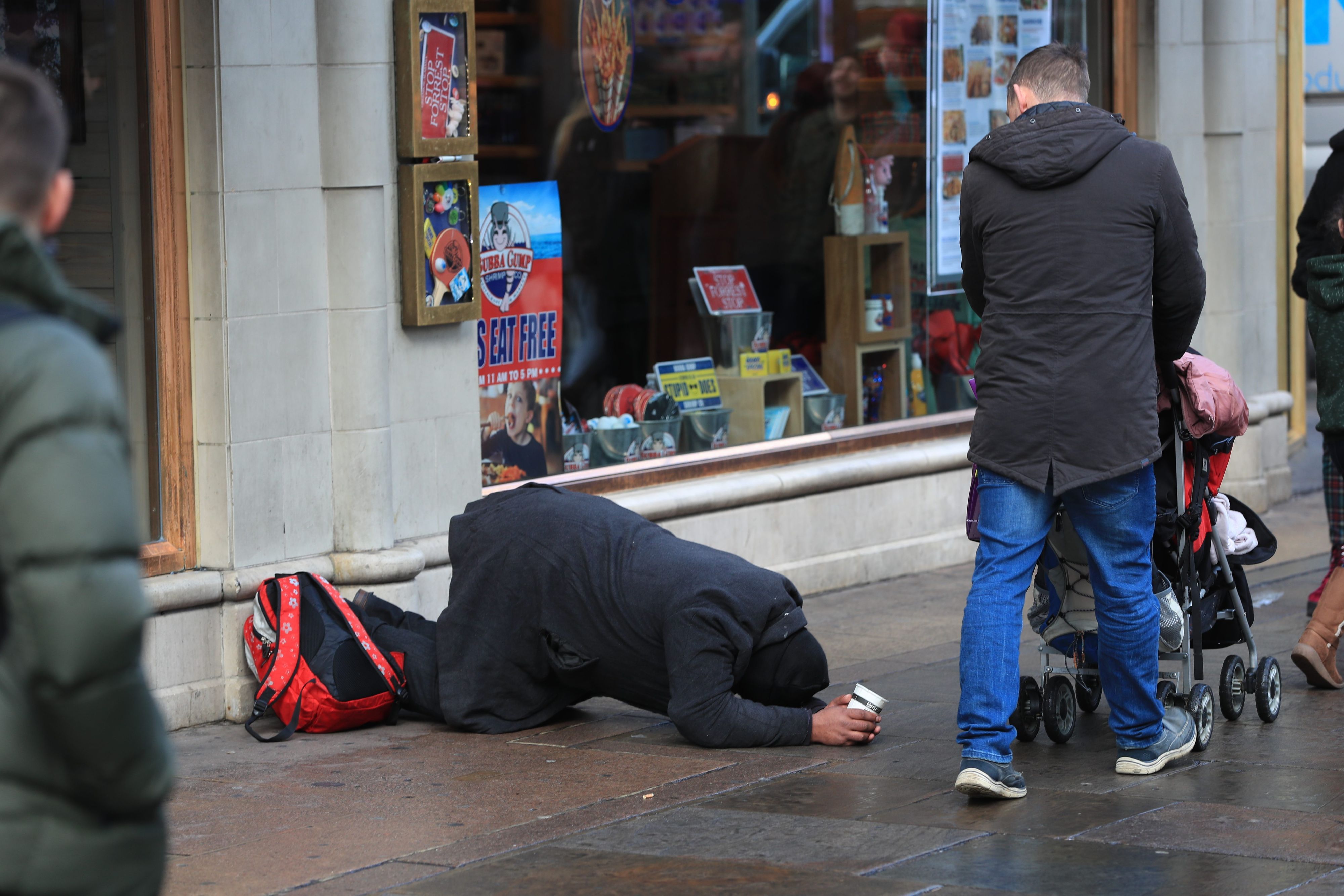 Ein Mann ‚bettelt‘ auf der Straße um Geld.