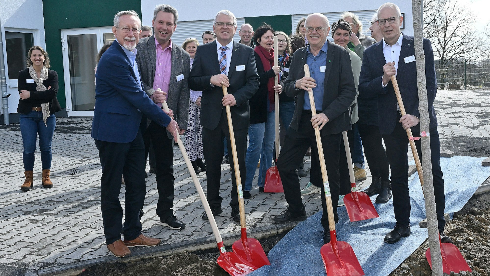 Beteiligte Männer nehmen einen symbolischen Spatenstich vor.