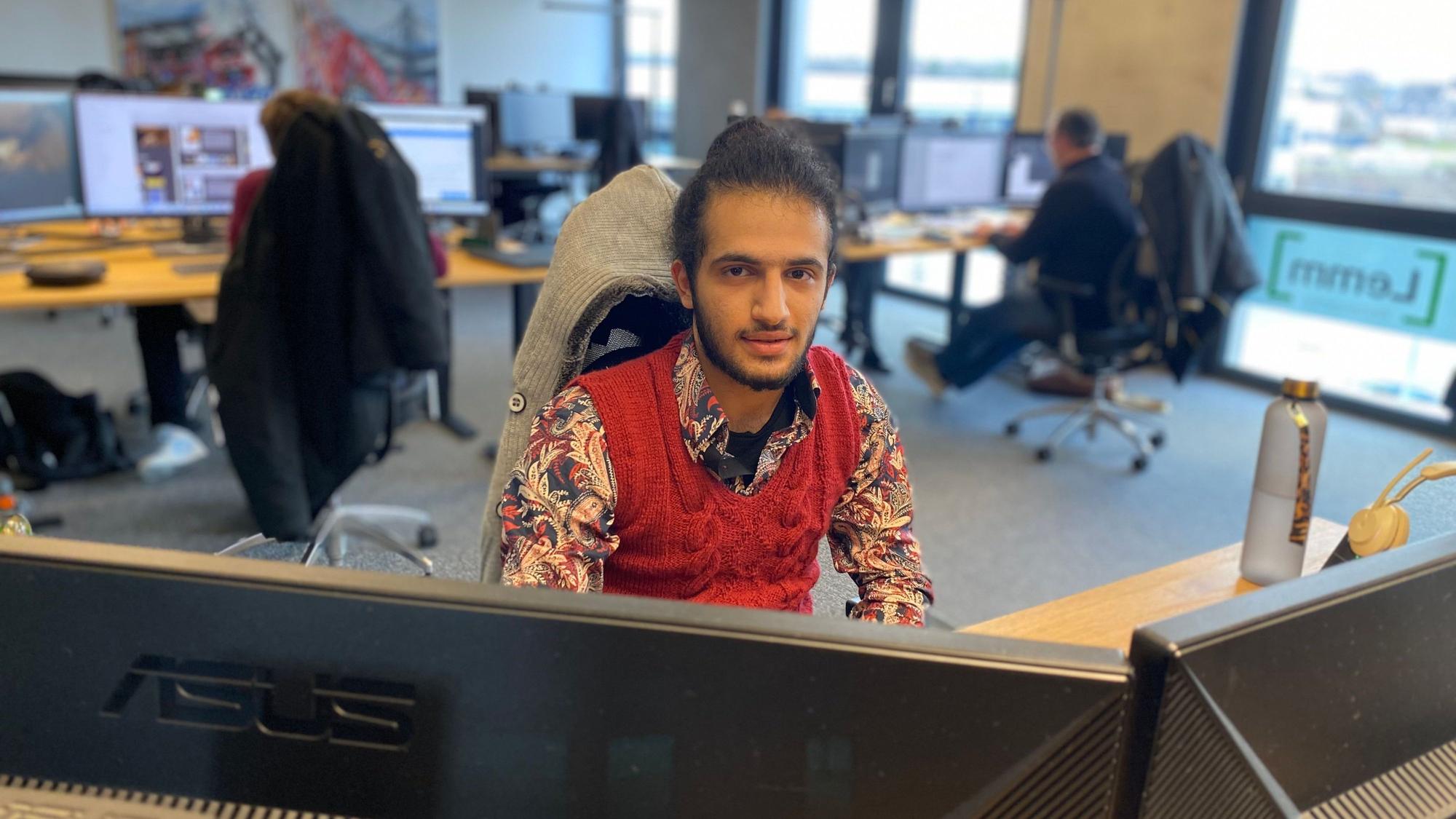 Der 21-jährige Mustapha Attar sitzt an einem der Arbeitsplätze in der Werbeagentur Lemm.