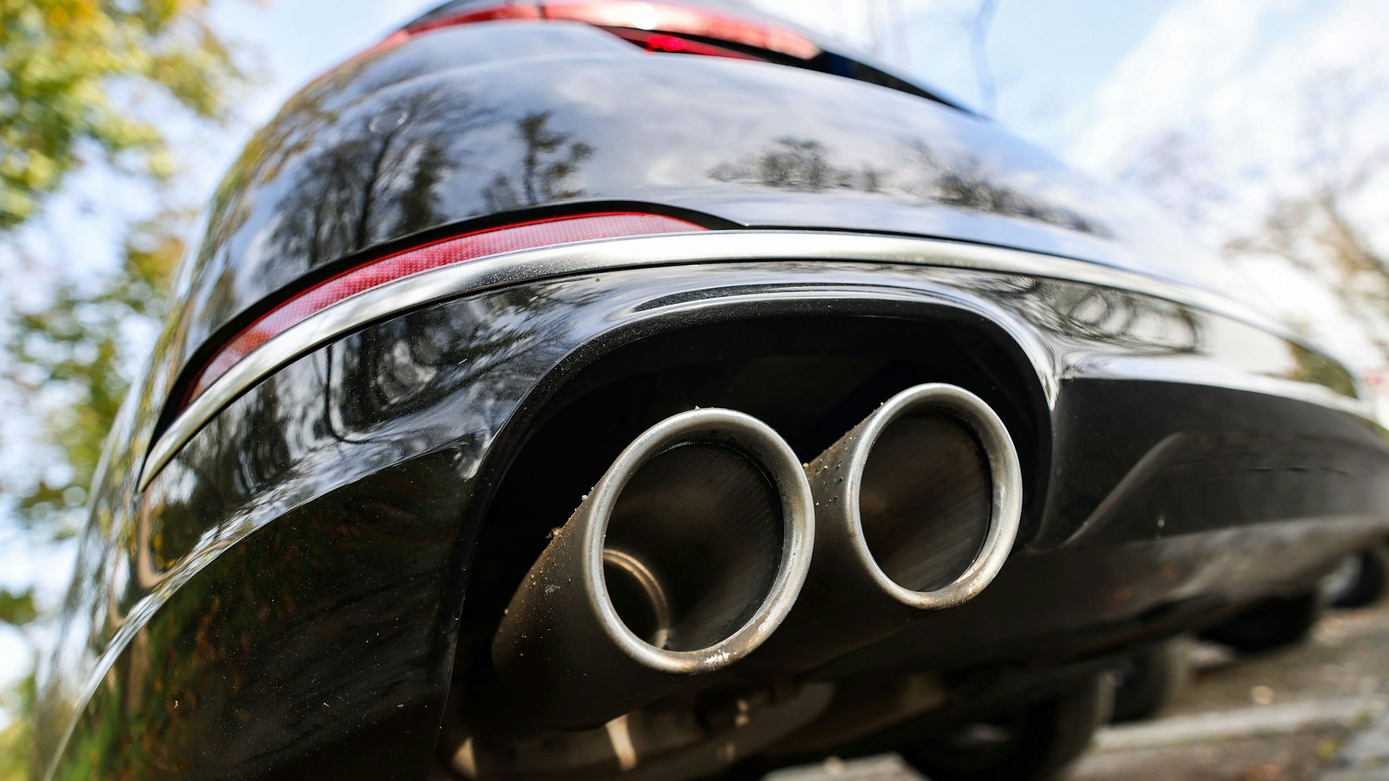 Ein Pkw mit doppeltem Auspuff steht auf einem Parkplatz. In der EU dürfen ab 2035 keine Neuwagen mehr verkauft werden, die mit Benzin oder Diesel fahren.