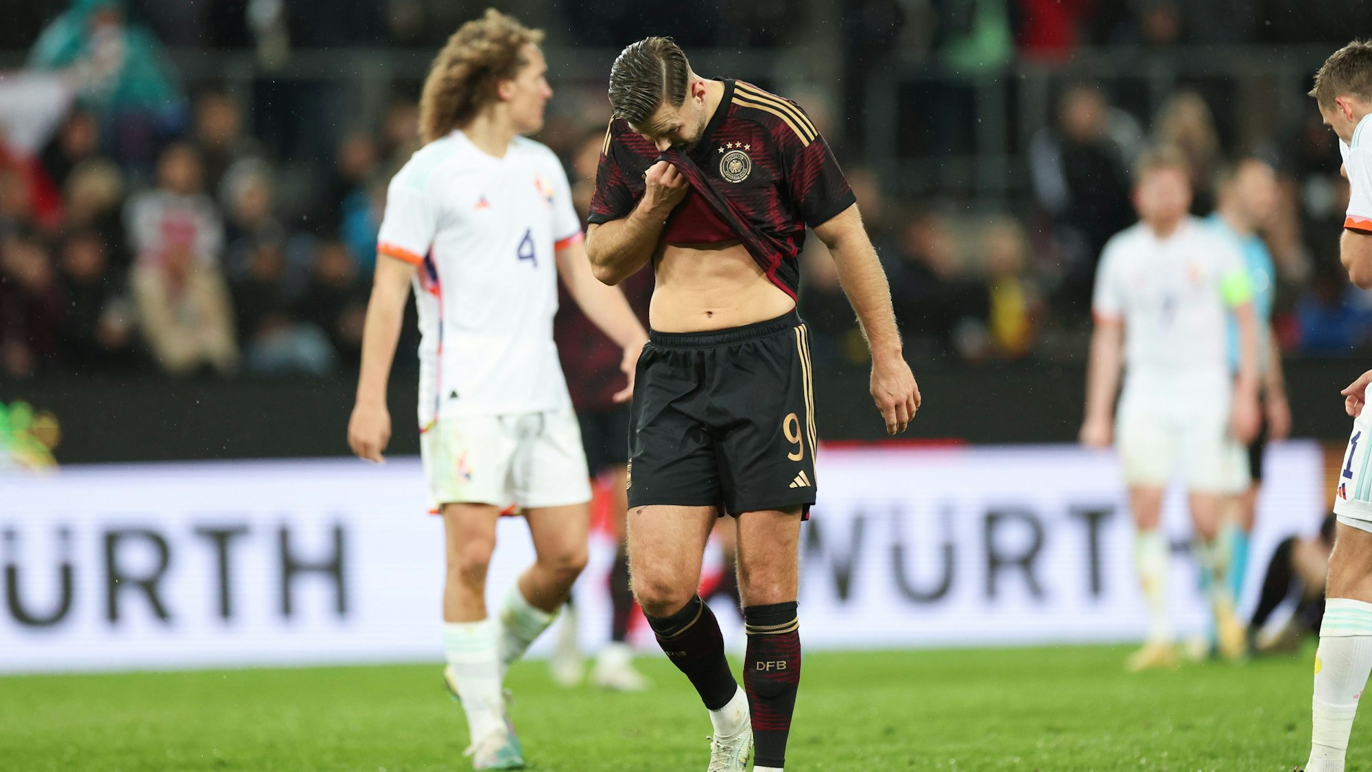 Deutschlands Niclas Füllkrug wischt sich den Schweiß vonm Gesicht.