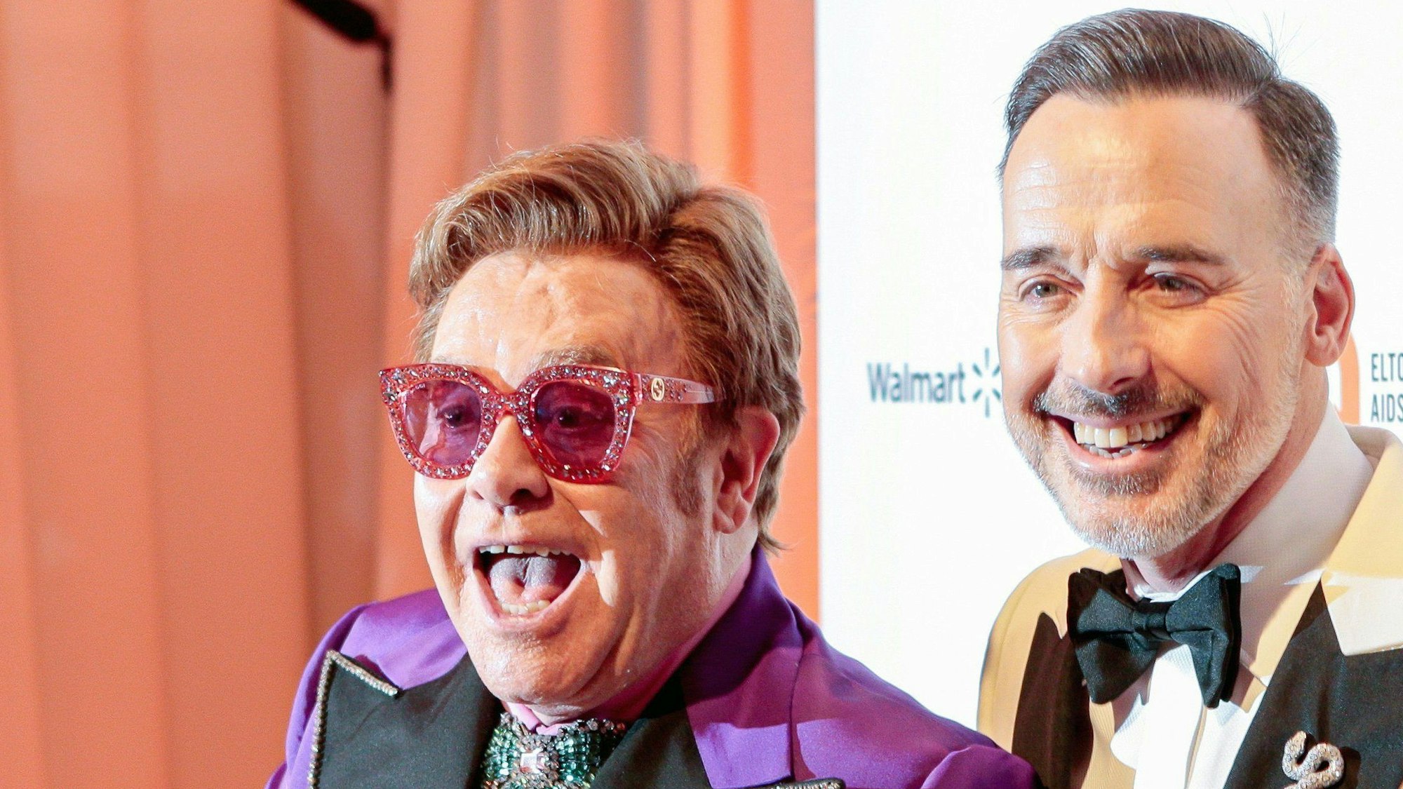 Der britische Popstar Elton John (l) und sein Mann David Furnish (r) feiern bei der Elton John AIDS Foundation Viewing Party im West Hollywood Park den erhaltenen Oscar.