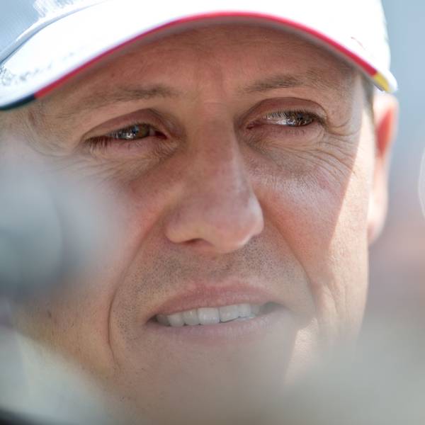 Der deutsche Formel-1-Pilot Michael Schumacher blickt lächelnd in die Kamera. Er trägt eine Kappe seines Teams Mercedes.