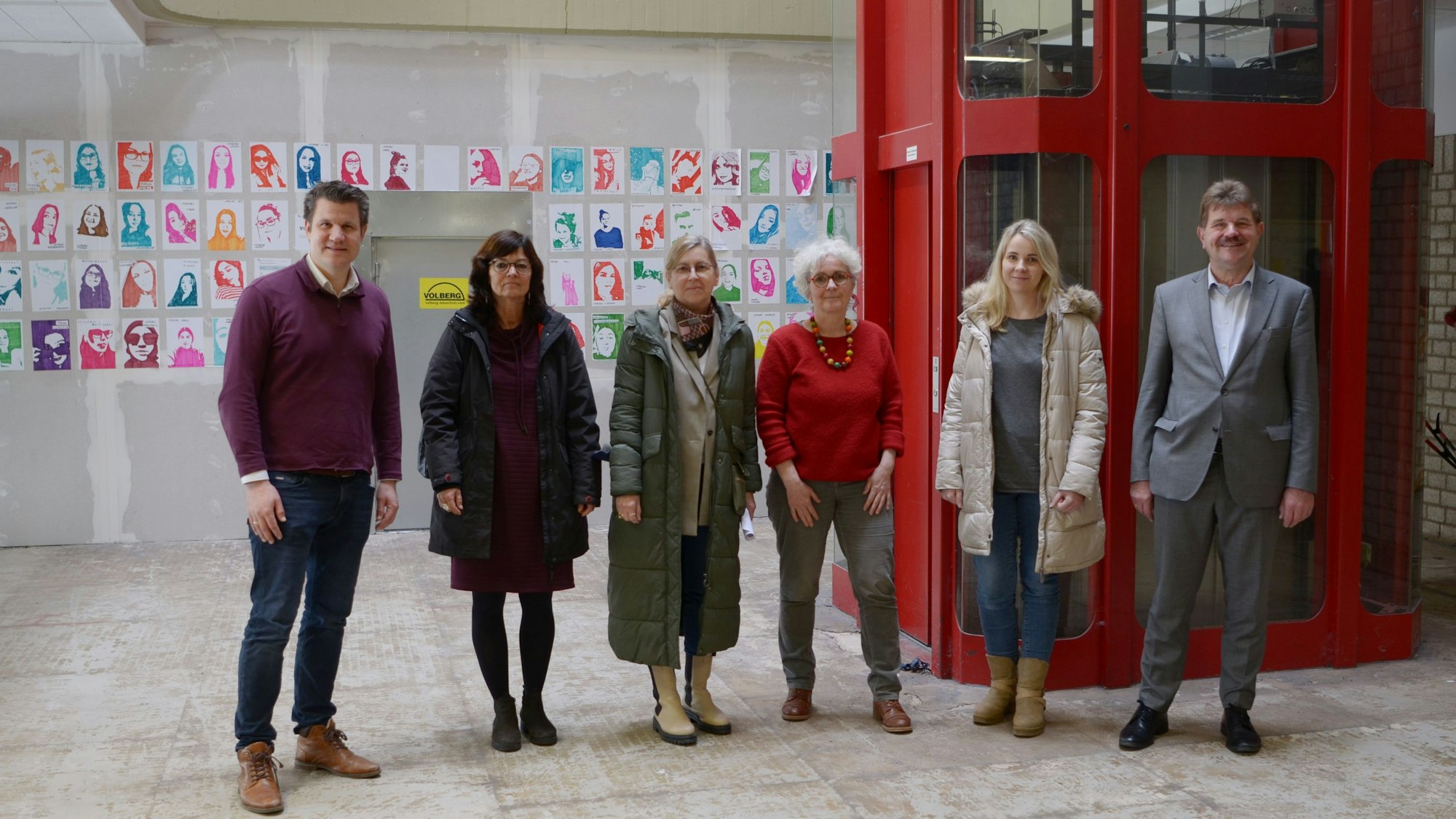 Sechs Personen stehen in einer Reihe nebeneinander.