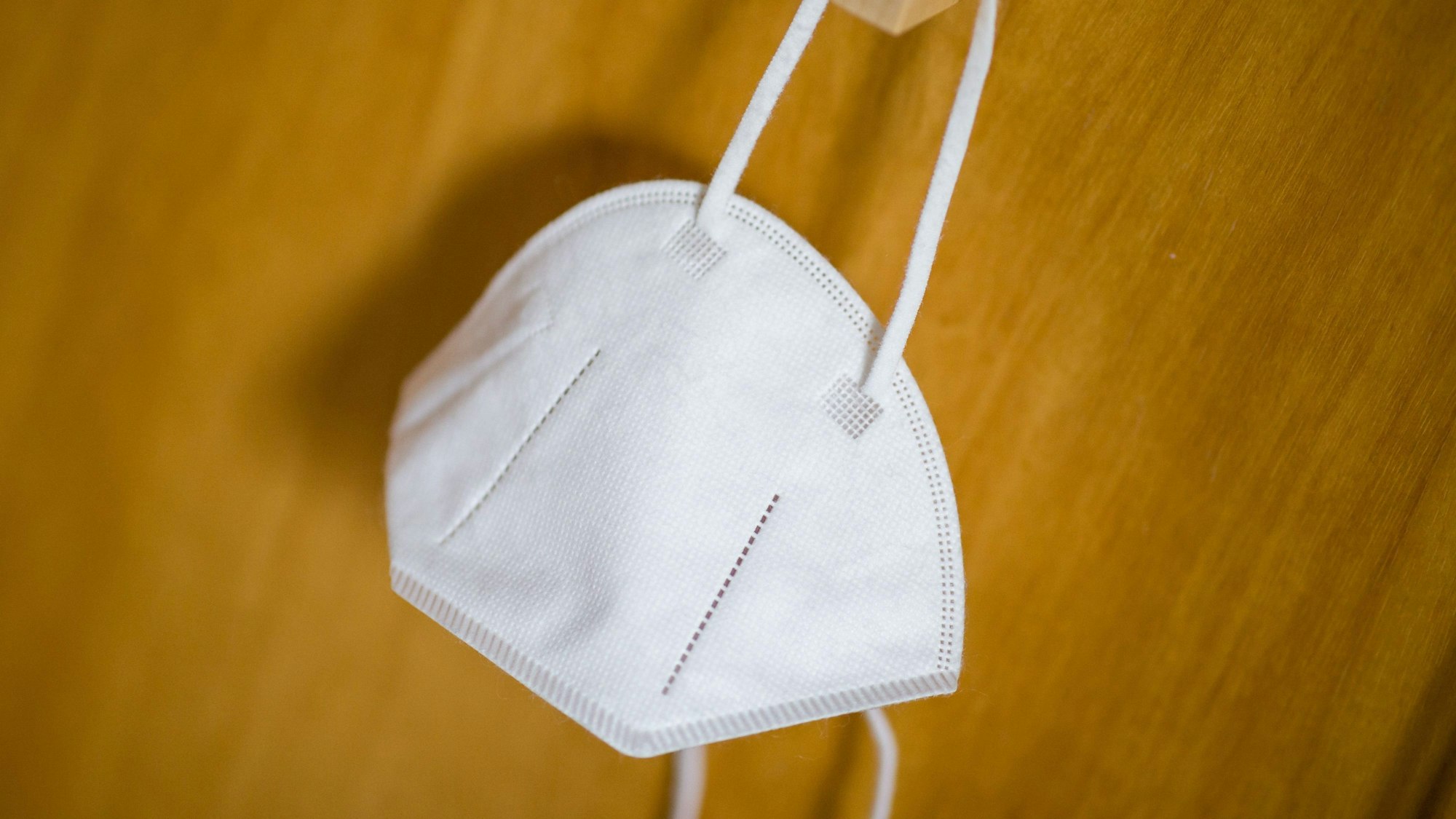 Eine FFP2-Maske hängt an einem Haken.