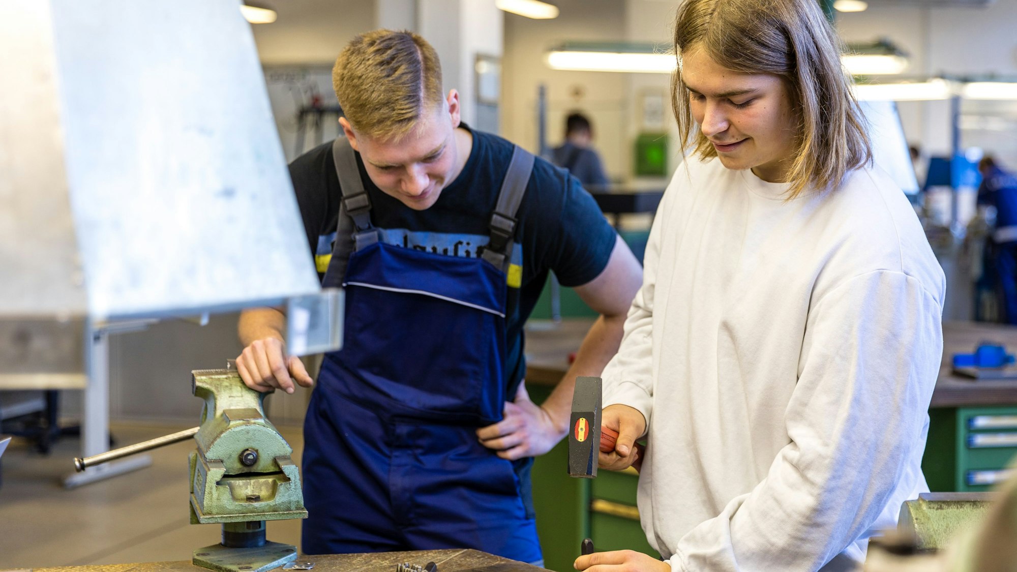 Ein Auszubildender zeigt einem Besucher ein Handwerk.
