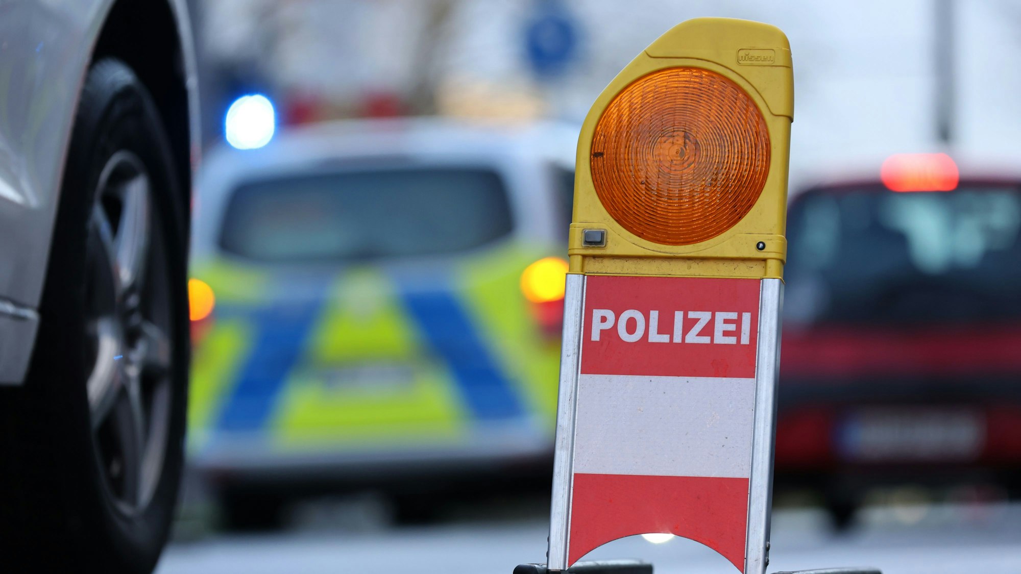 Eine Polizei-Warnbake steht auf einer Straße. (Symbolbild)