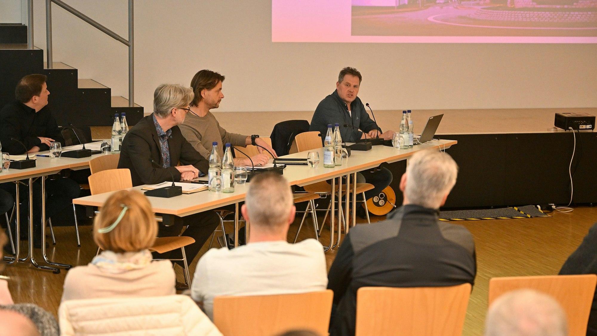 Mitarbeiter der Stadtverwaltung sitzen vorne an einem Tisch und informierten die Bürger über den Ablauf der Straßensanierung.