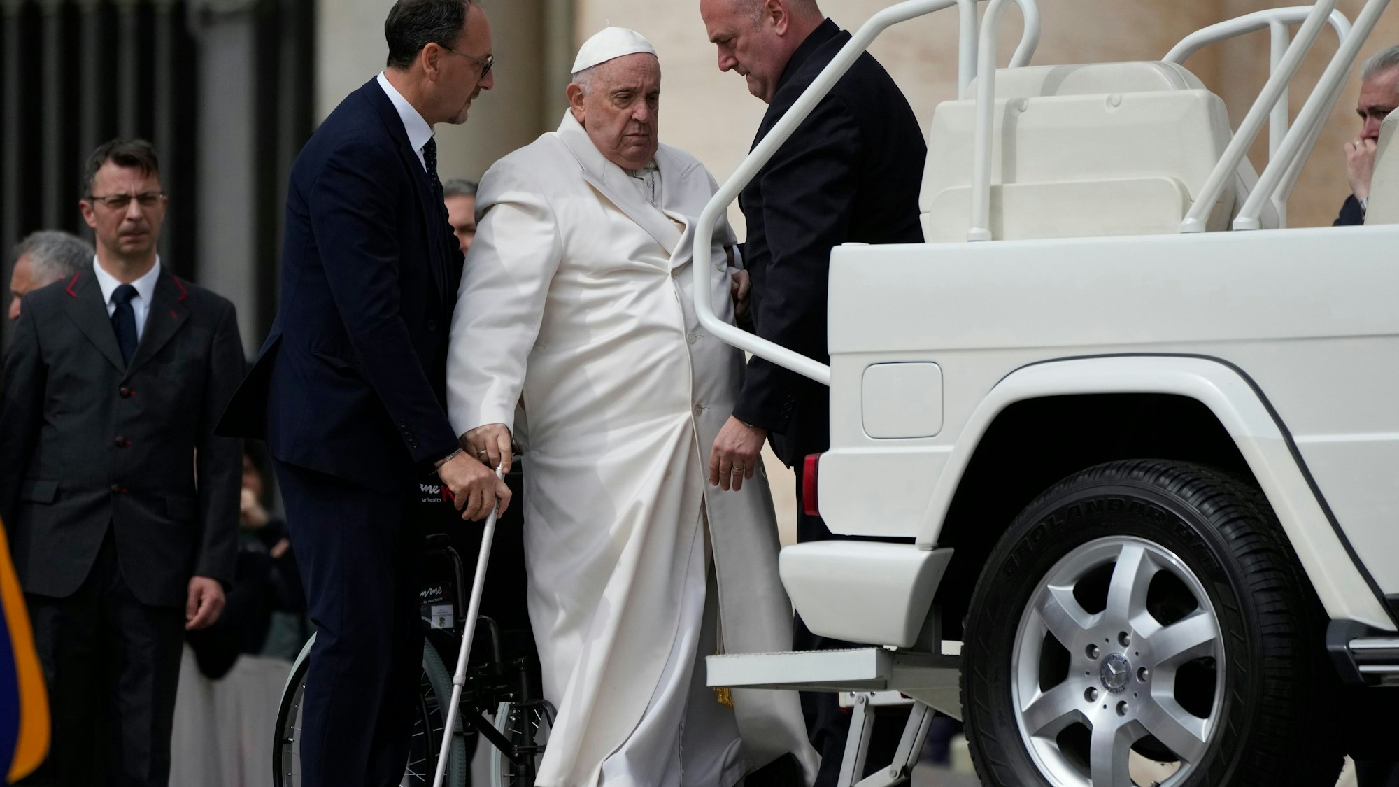 29.03.2023, Vatikan, Vatikanstadt: Papst Franziskus (2.v.r) wird am Ende der wöchentlichen Generalaudienz auf dem Petersplatz in sein Auto geholfen.