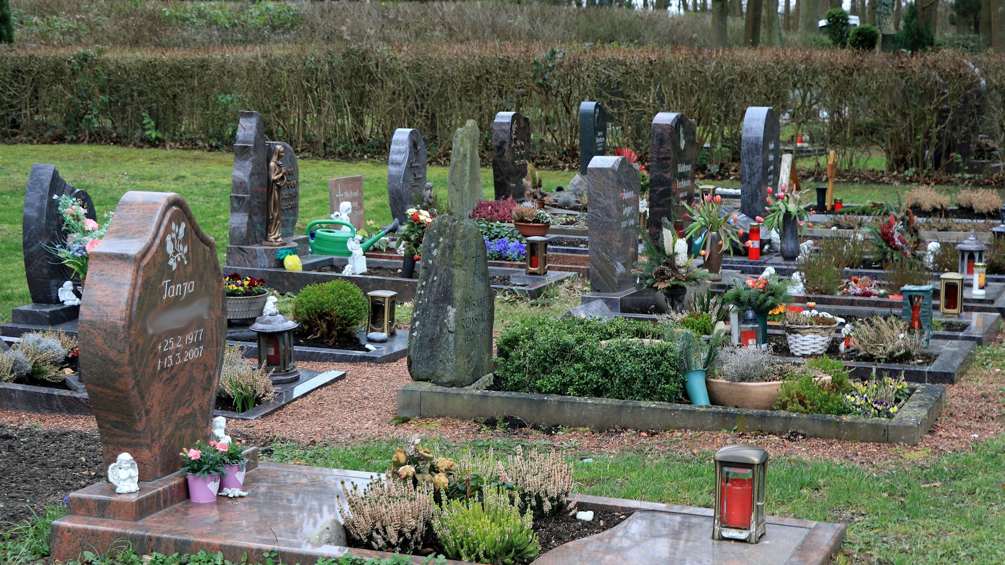 Grabsteine stehen auf einem Friedhof.