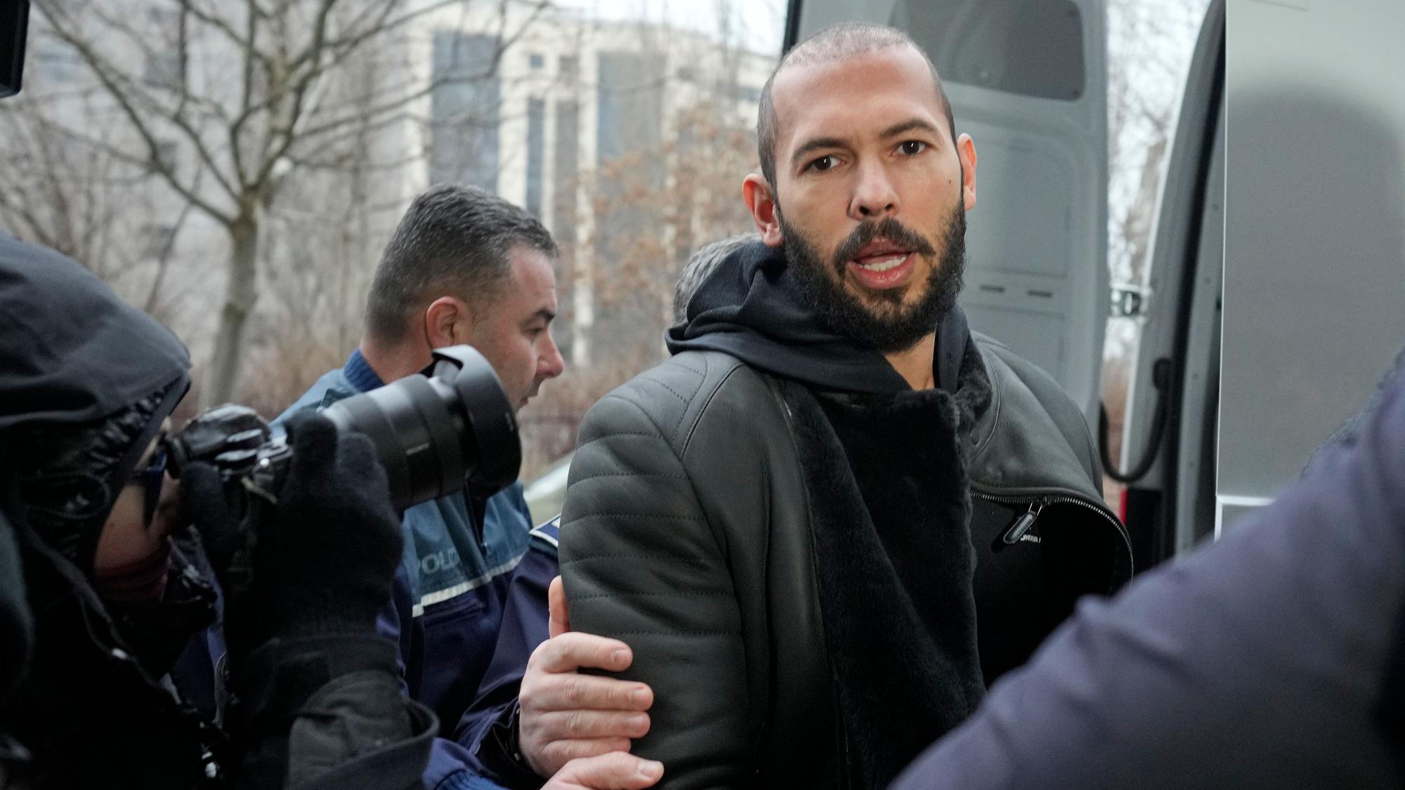 Polizeibeamte eskortieren Andrew Tate.