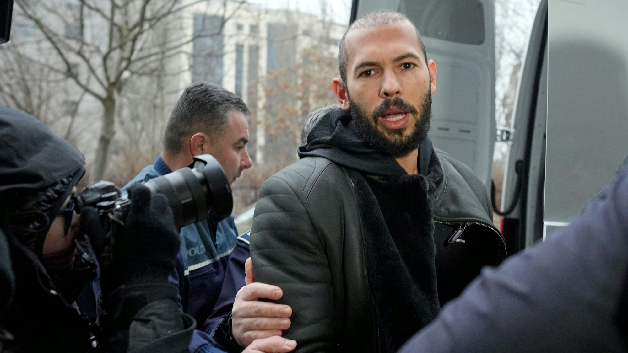 Polizeibeamte eskortieren Andrew Tate.