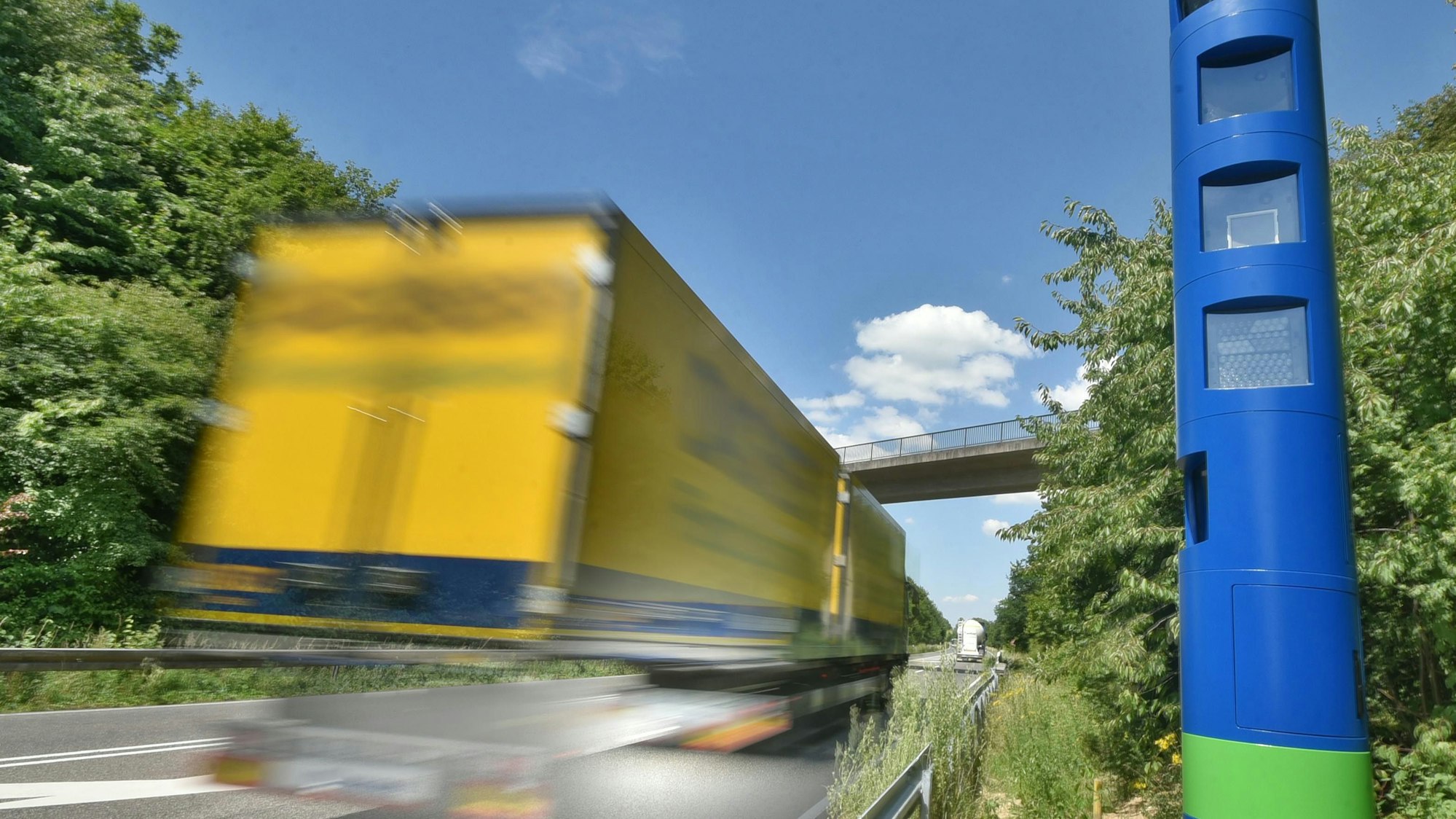 Das Bild zeigt einen Lkw, der an einer Maut-Kontrollsäule vorbeifährt.