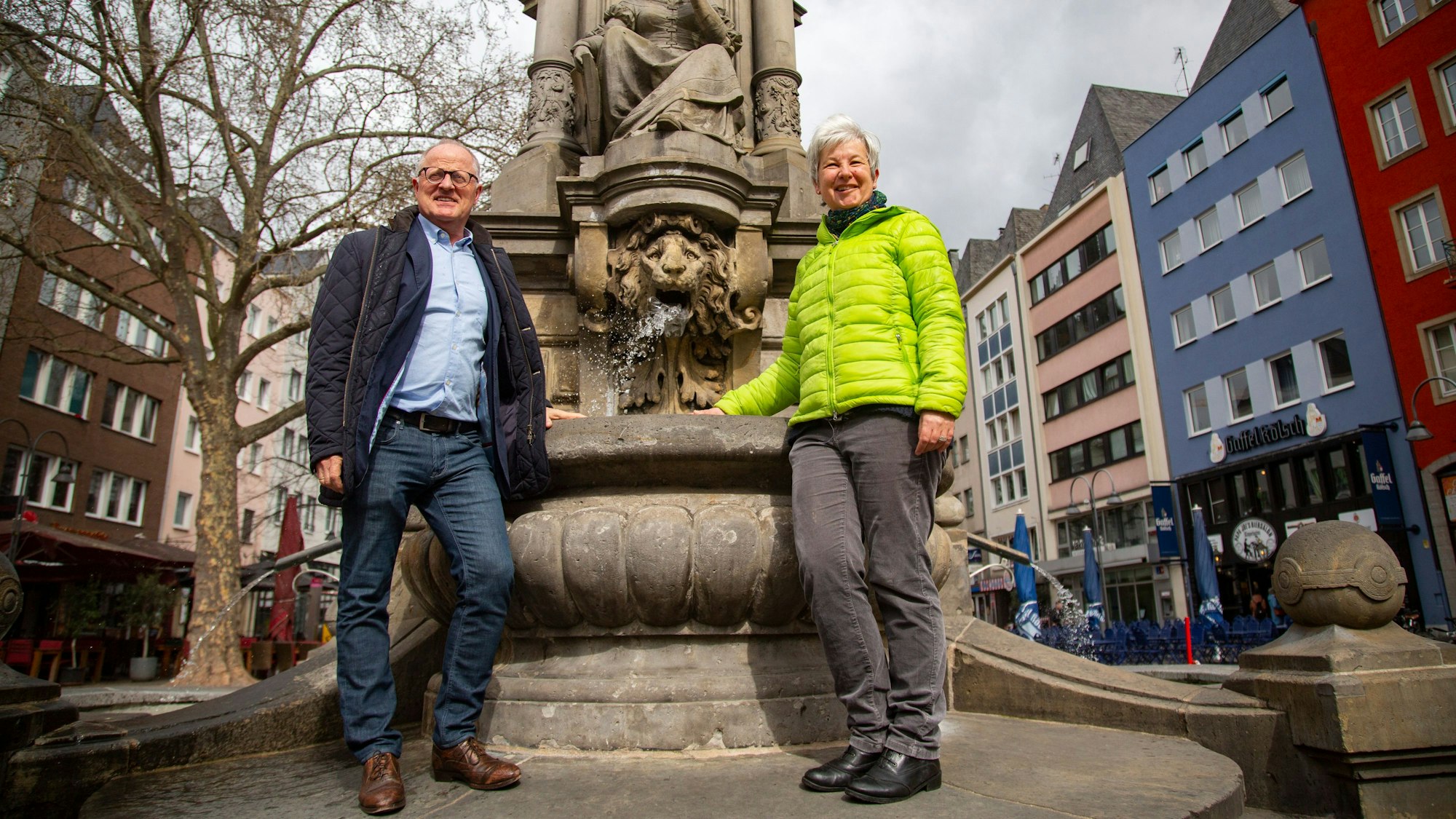 Es läuft wieder: Manfred Kaune, Leiter des Grünflächenamts, und Ute Götz-König von der Gebäudewirtschaft eröffnen die Brunnensiaon auf dem Alter Markt. Zwei Männer stehen vor einem Brunnen.