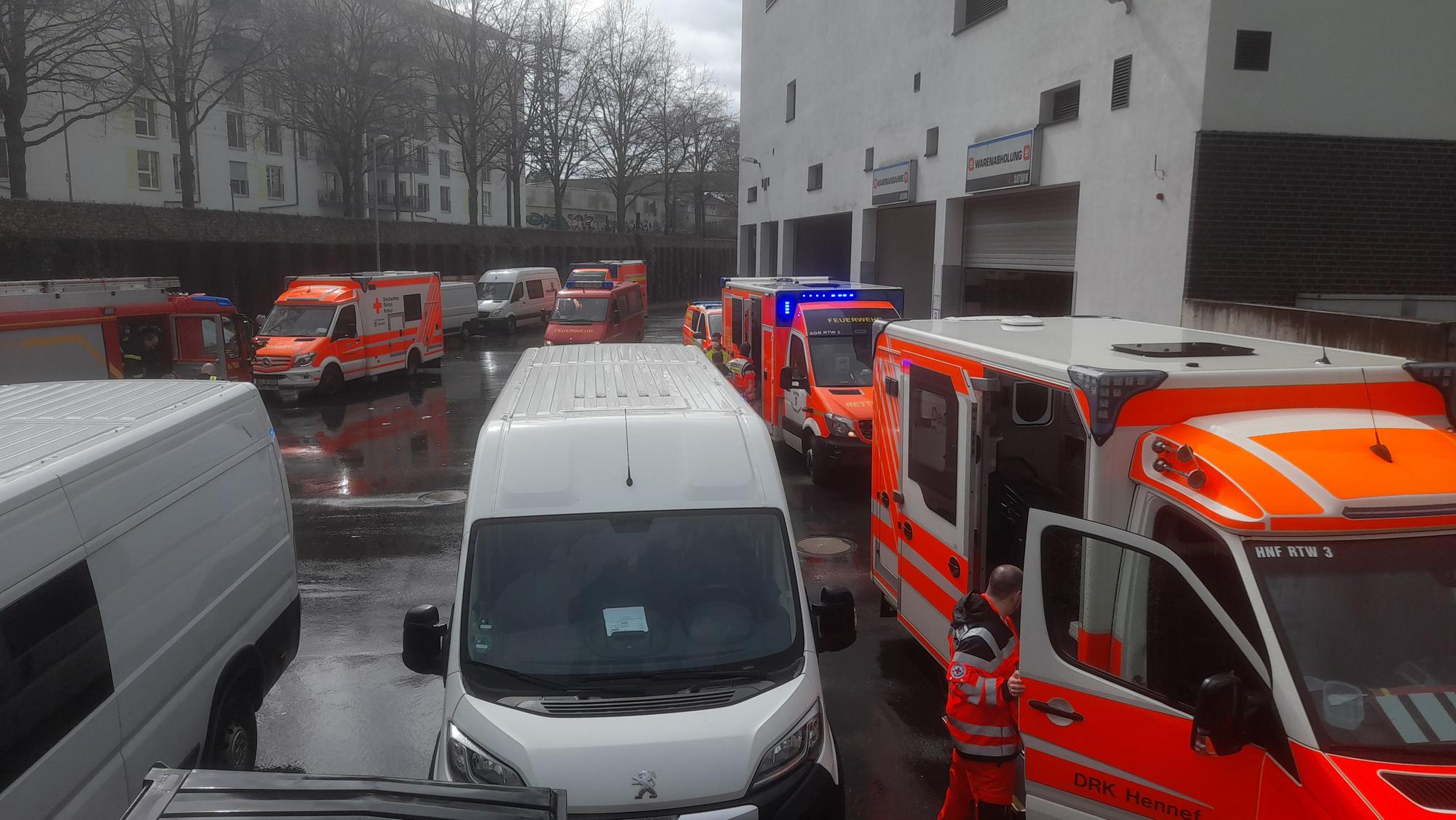 Etliche Rettungsfahrzeuge stehen auf dem Parkplatz neben einem Gebäude, auch zwei Kastenwägen sind dort geparkt.