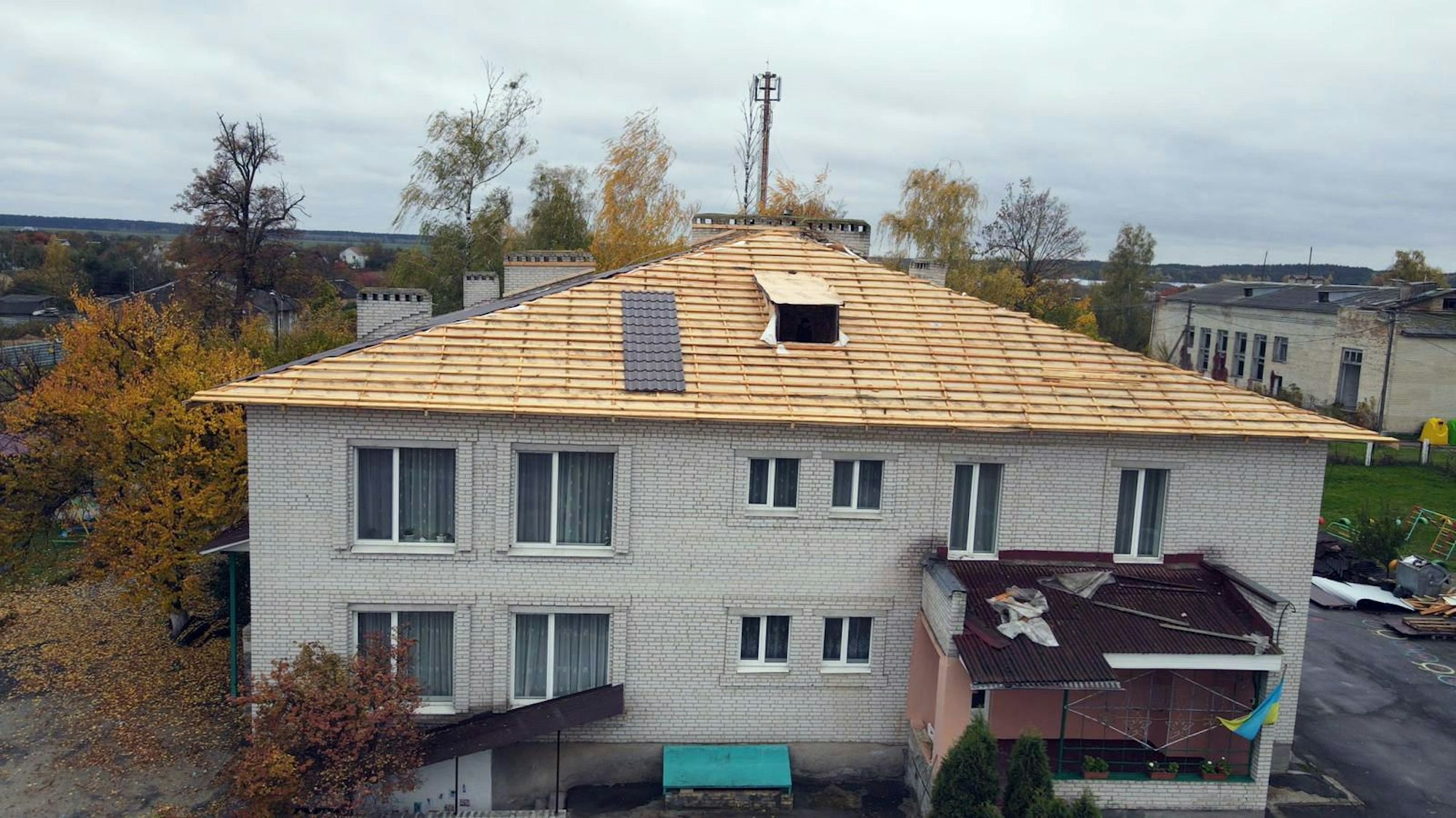 Das durch russischen Beschuss zerstörte Dach eines großen Gebäudes im ukrainischen Butscha wird neu gedeckt.